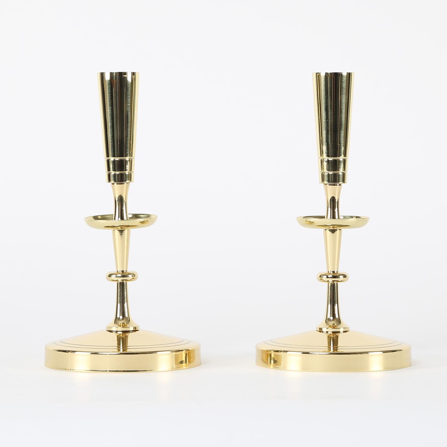 Pair of candelabra, each holding 1 candle, in polished brass with engraved concentric circles, by Tommi Parzinger for Dorlyn Silversmiths, American, 1950’s (signed on bottom “Dorlyn Silversmiths”).