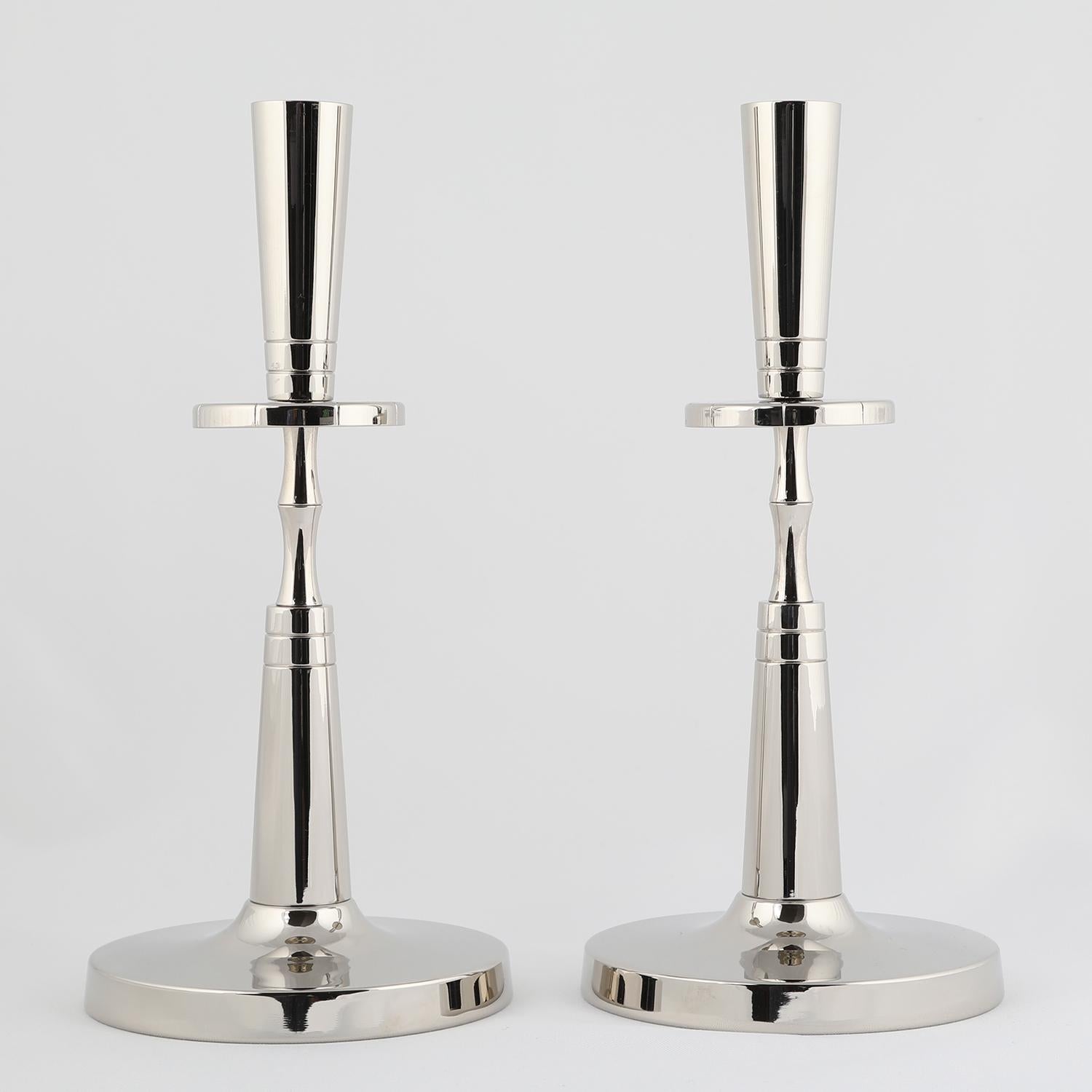 Pair of elegant candelabra in polished nickel, each holding 1 candle, each engraved with radiating lines, by Tommi Parzinger for Mueck-Cary, American 1950’s (signed on bottom “Mueck-Cary”).