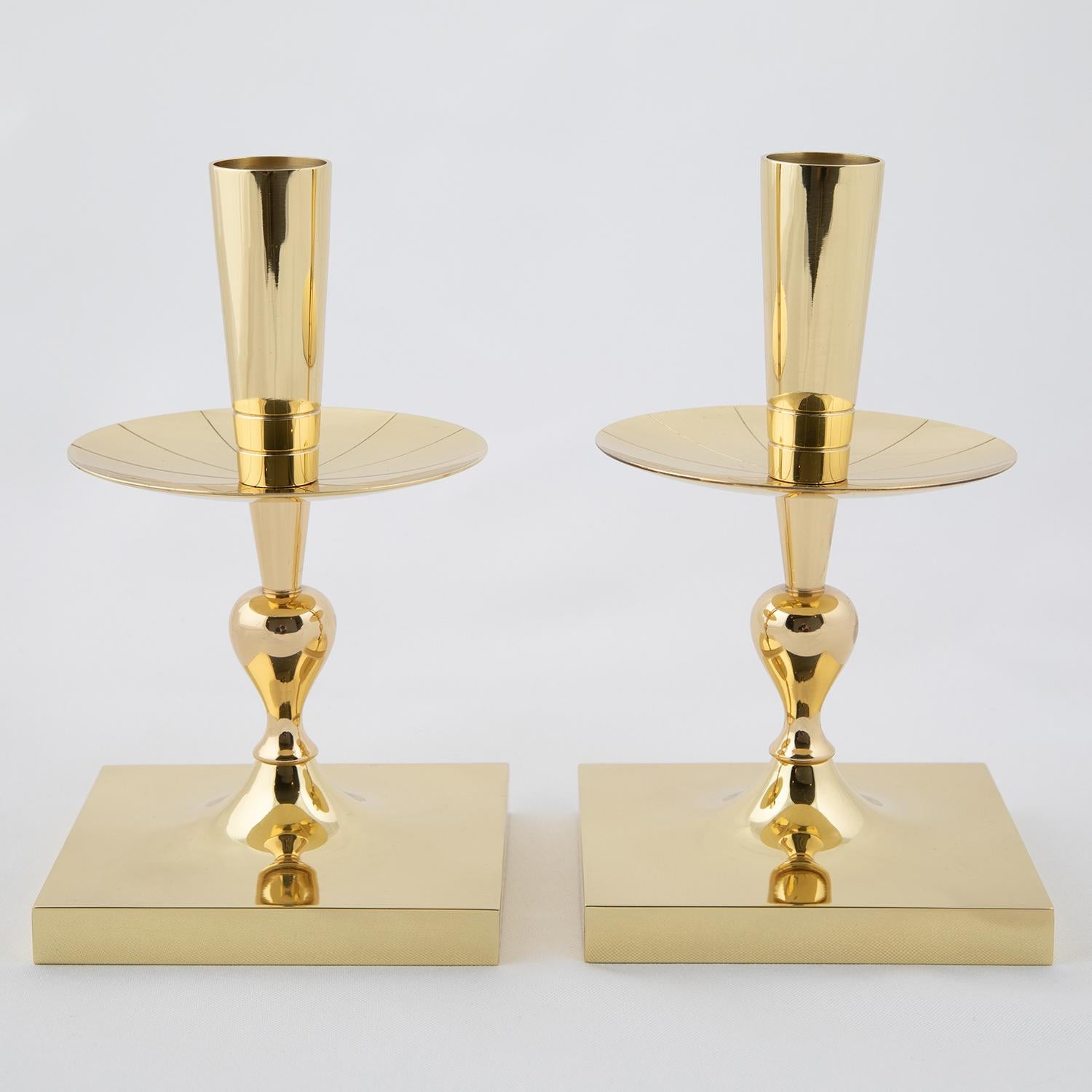 Pair of elegant candelabra, each holding 1 candle, in polished brass with engraved radiating lines, by Tommi Parzinger for Dorlyn Silversmiths, American, 1950's (signed “Dorlyn-Silversmiths”).