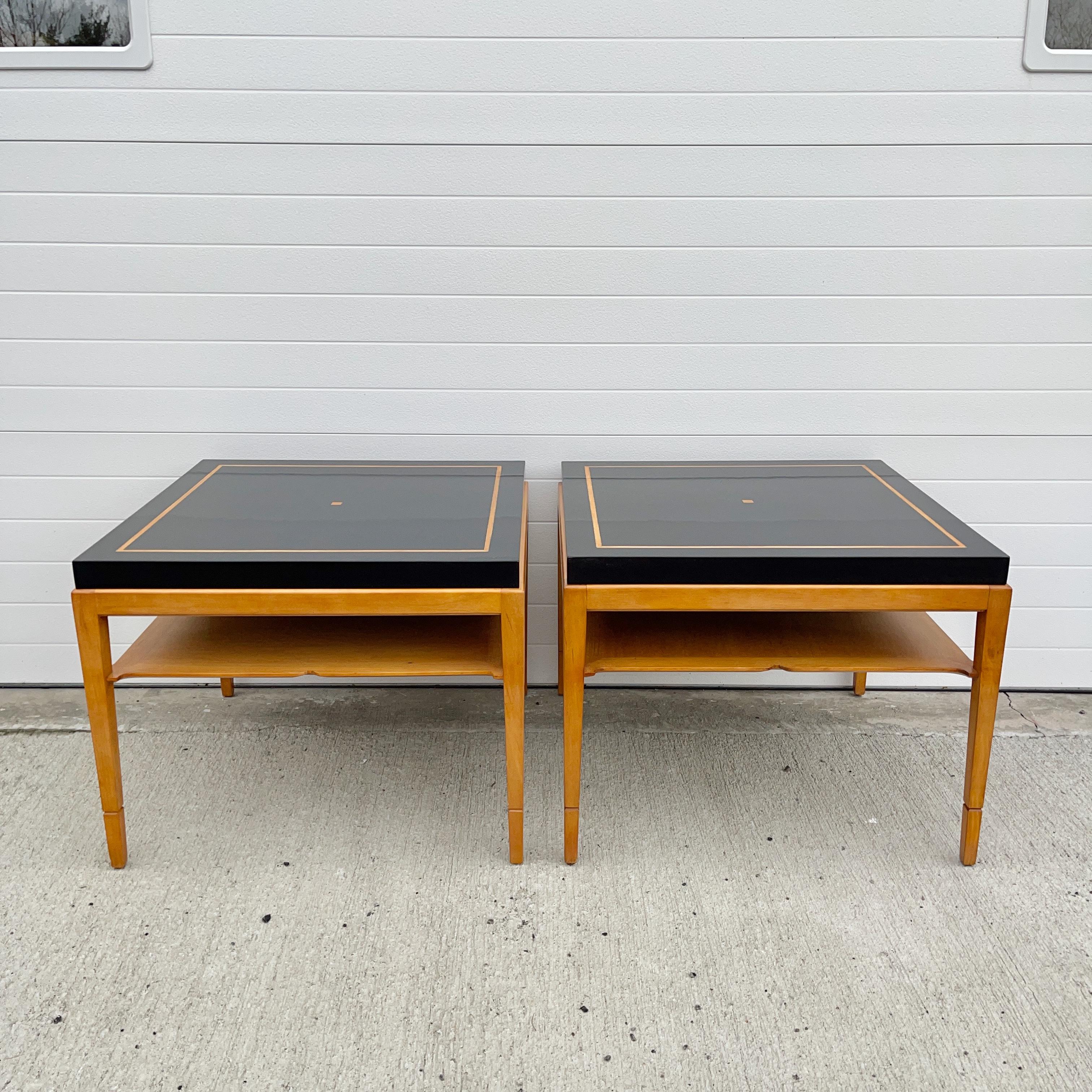 Elegant pair of side or end tables by Tommi Parzinger of square form, ebonized walnut top with caramel colored inlay and body made of holly with stylized hand carved fixed shelf and tapered legs.
These are equally beautiful when viewed from