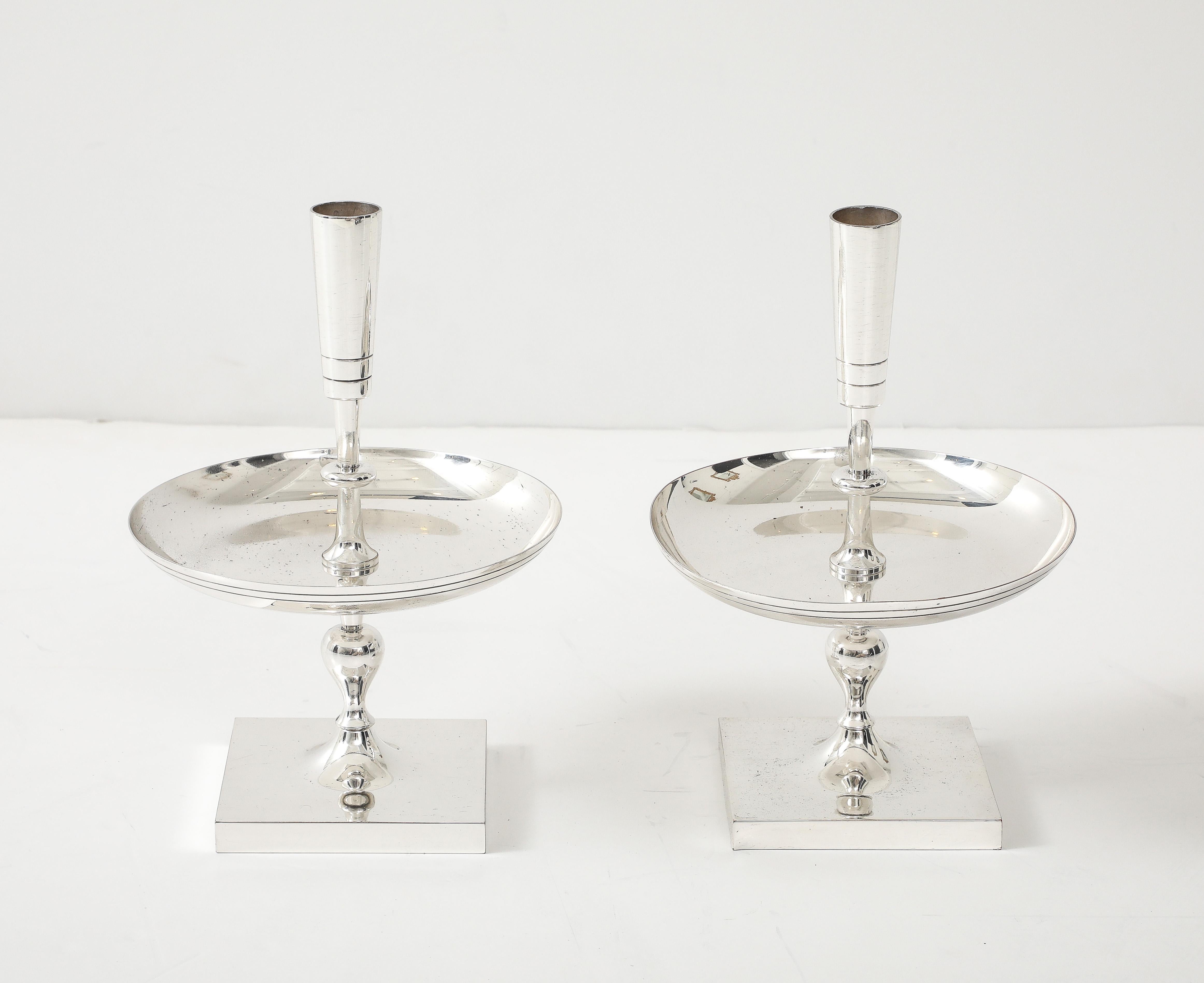 Pair of impressive polished nickel candlesticks with wax catching discs. Designed by Tommi Parzinger.