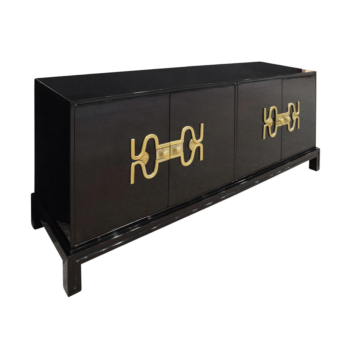 Rare and important 4 door credenza in high gloss black lacquer with exquisite brass hardware by Tommi Parzinger for Parzinger Originals, American, 1960s. This is an incredibly chic design and the hardware design is extraordinary. Newly lacquered.