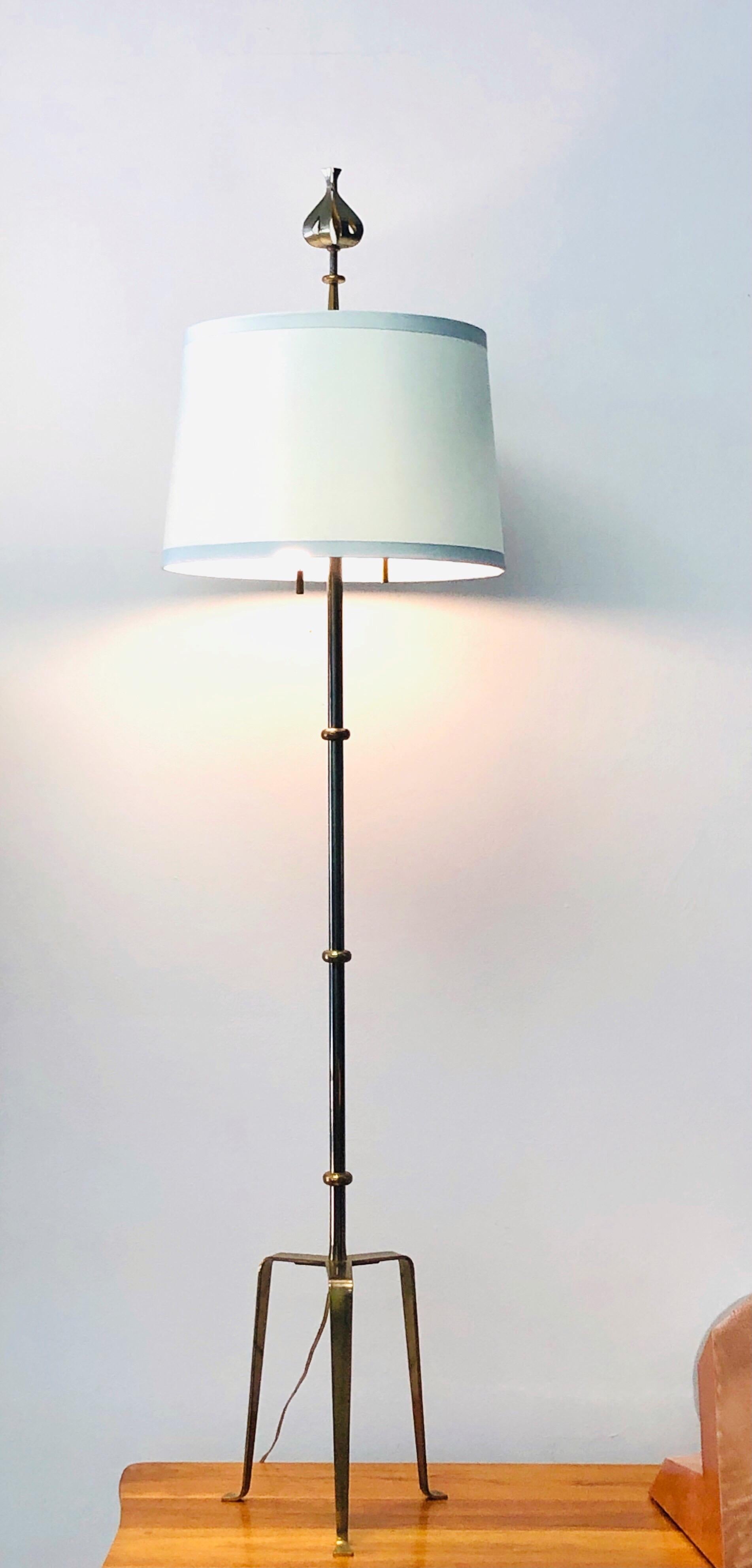 A rare floor lamp by Tommi Parzinger. Slender form on a tripod base and crowned by his most iconic finial.