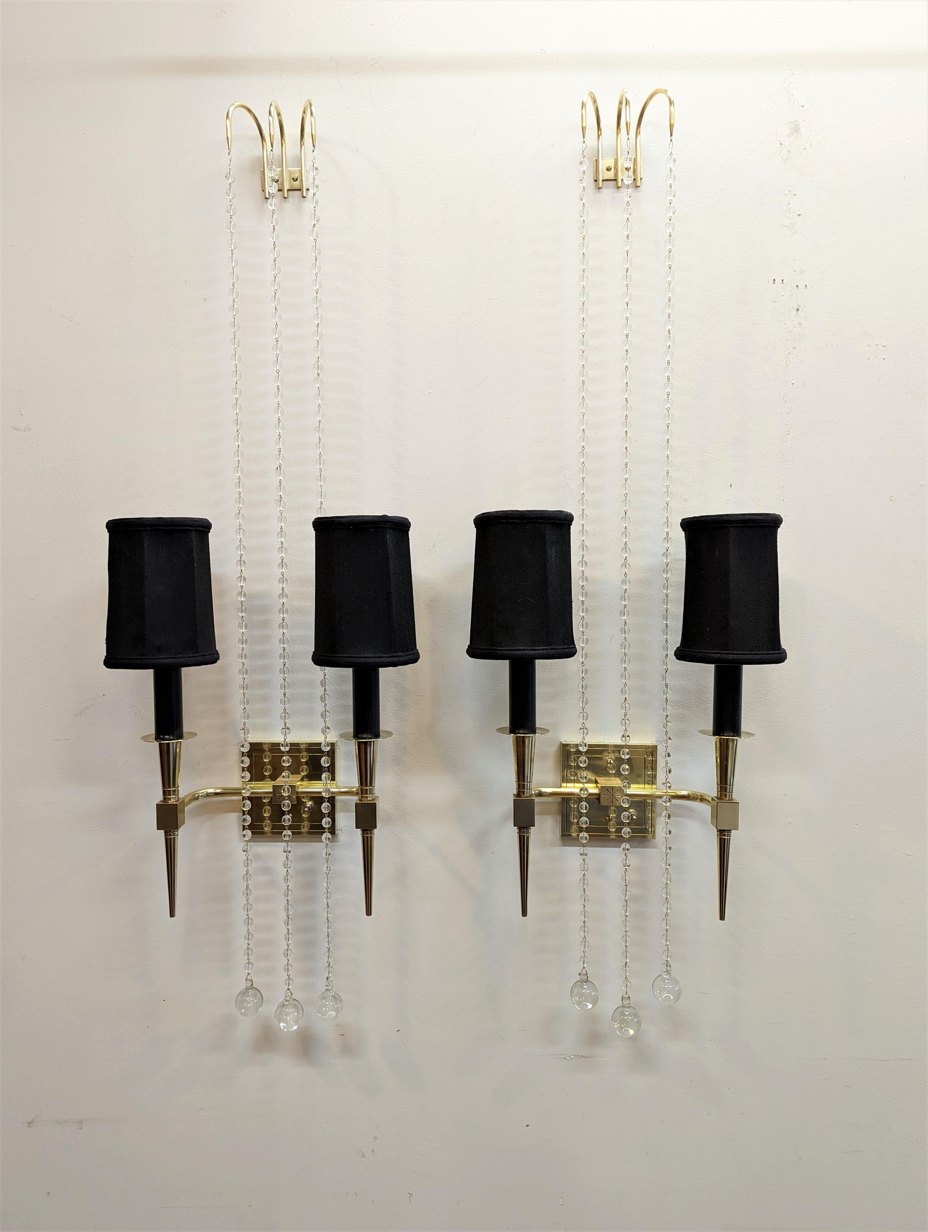 Pair of Tommi Parzinger sconces model no 12 in brass with suspended crystals and silk shades. Very elegant sconces that can be displayed in a couple of different variations. As shown height 46 inches and can be adjusted by adding or removing
