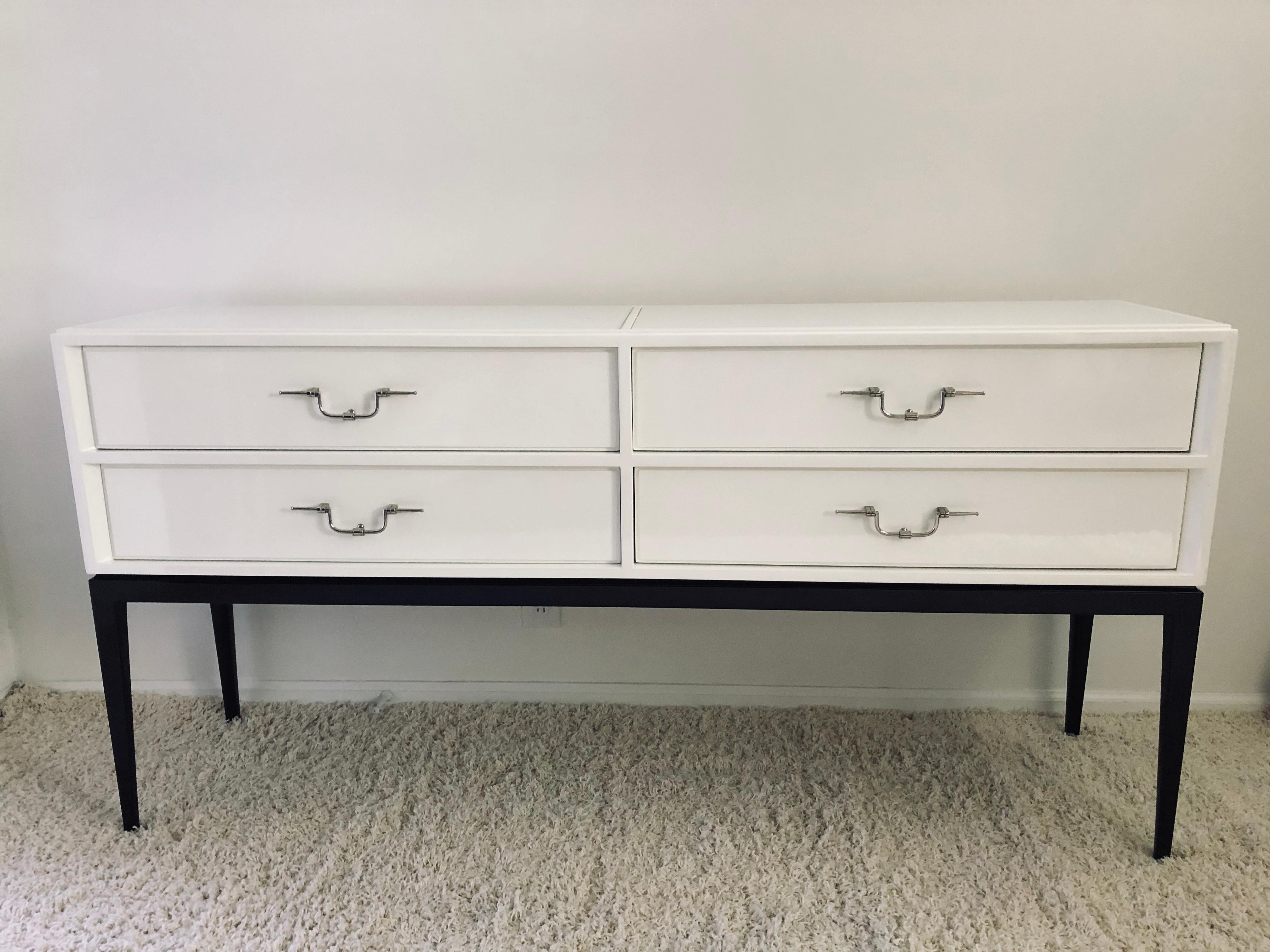 Tommi Parzinger white lacquer sideboard / chest with polished nickel swing pulls, white glass top panels, drawers lined in brown felt with dark walnut base.