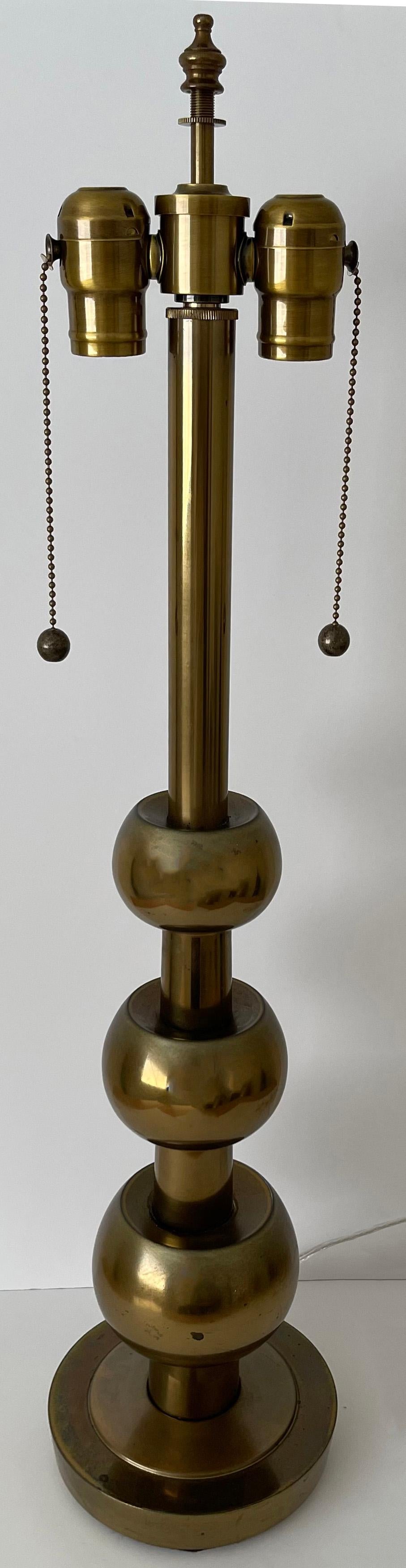 Mid-century brass Stiffel lamp in the style of Tommi Parzjnger. Stacked brass ball style with overall unpolished patina. Lamp is newly rewired with new double socket. Lamp takes 2 standard bulbs (not included). Lampshade is not included. Brass