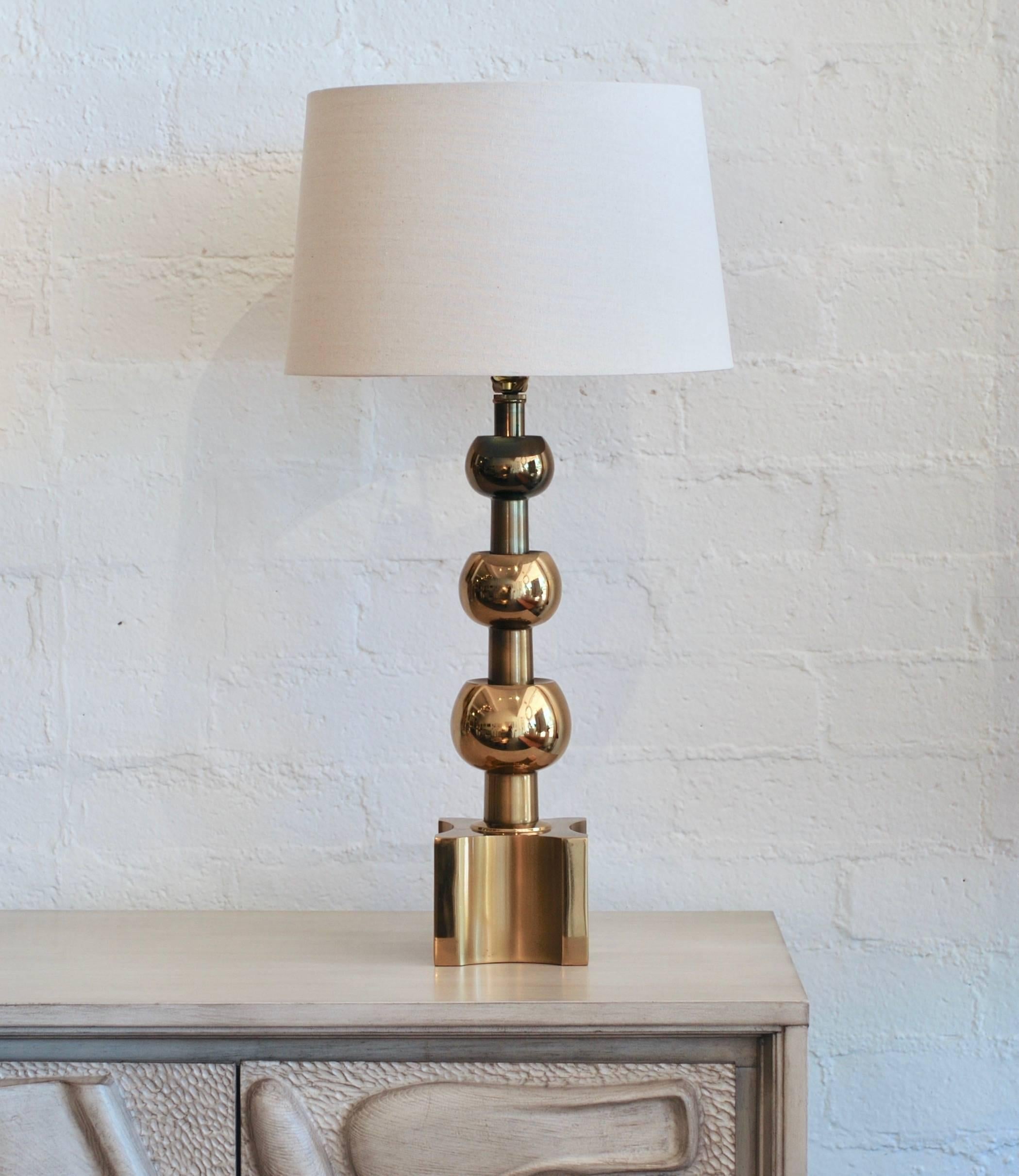 Manufactured by Stiffel and retaining the original label this brass table lamp has three orbs and a concave square base. The lamp base is 5 5/8
