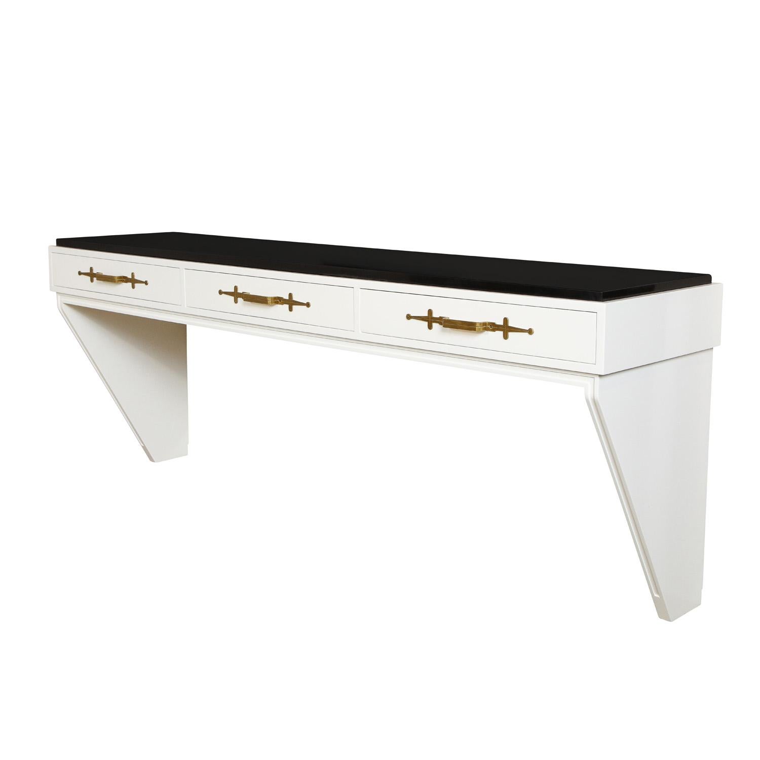 Elegant wall-mounted console table in white lacquer with inset black marble top and iconic etched brass pulls by Tommi Parzinger for Parzinger Originals, American, 1960's (signed). This console is emblematic of the superb craftsmanship and design of