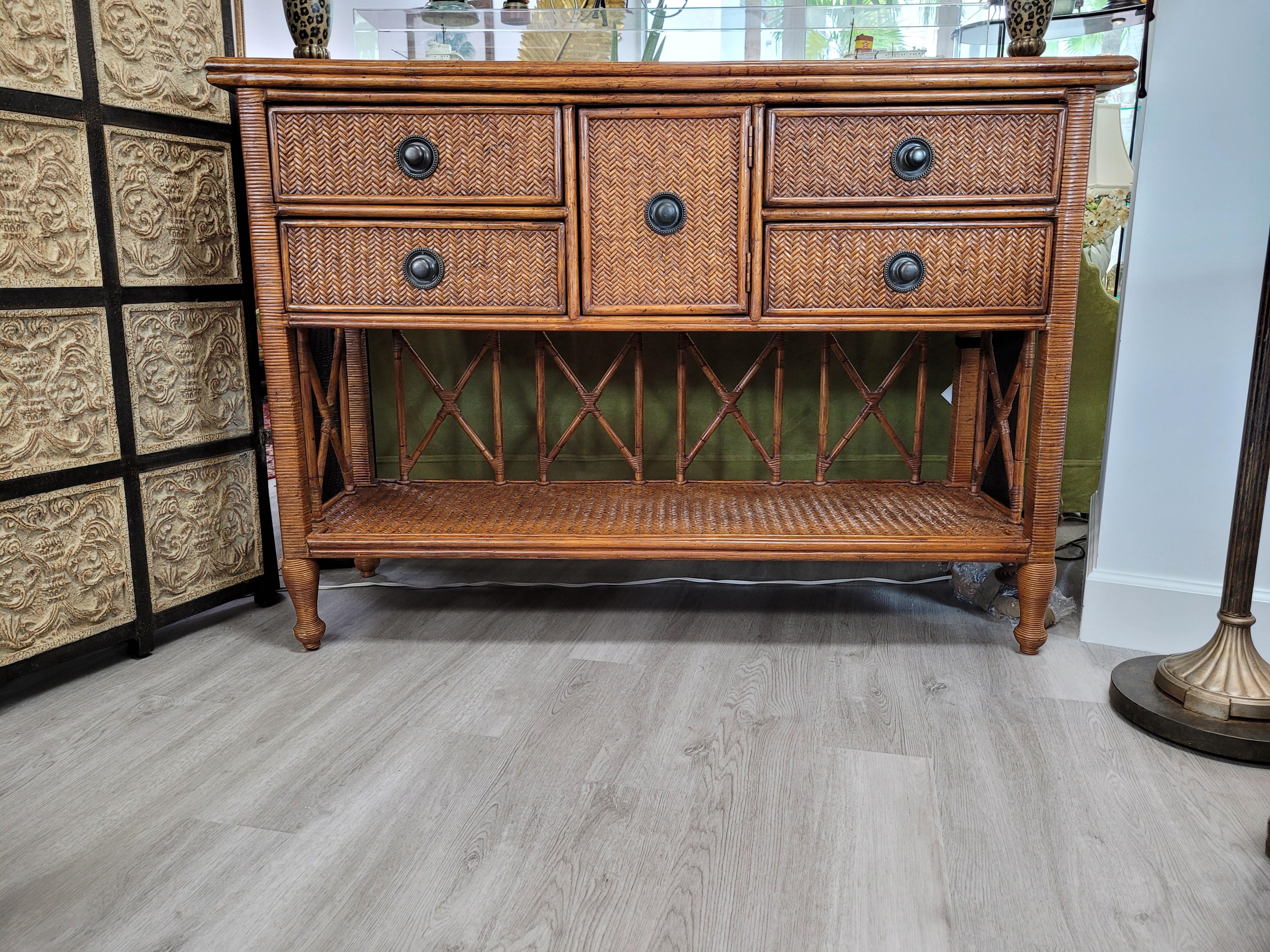 Un Aparador/Credenza Vintage Tommy Bahama que combina funcionalidad con belleza natural. El aparador cuenta con cuatro cajones y un armario de almacenaje central, que proporcionan un amplio espacio para organizar y guardar tus pertenencias. 

Hecha