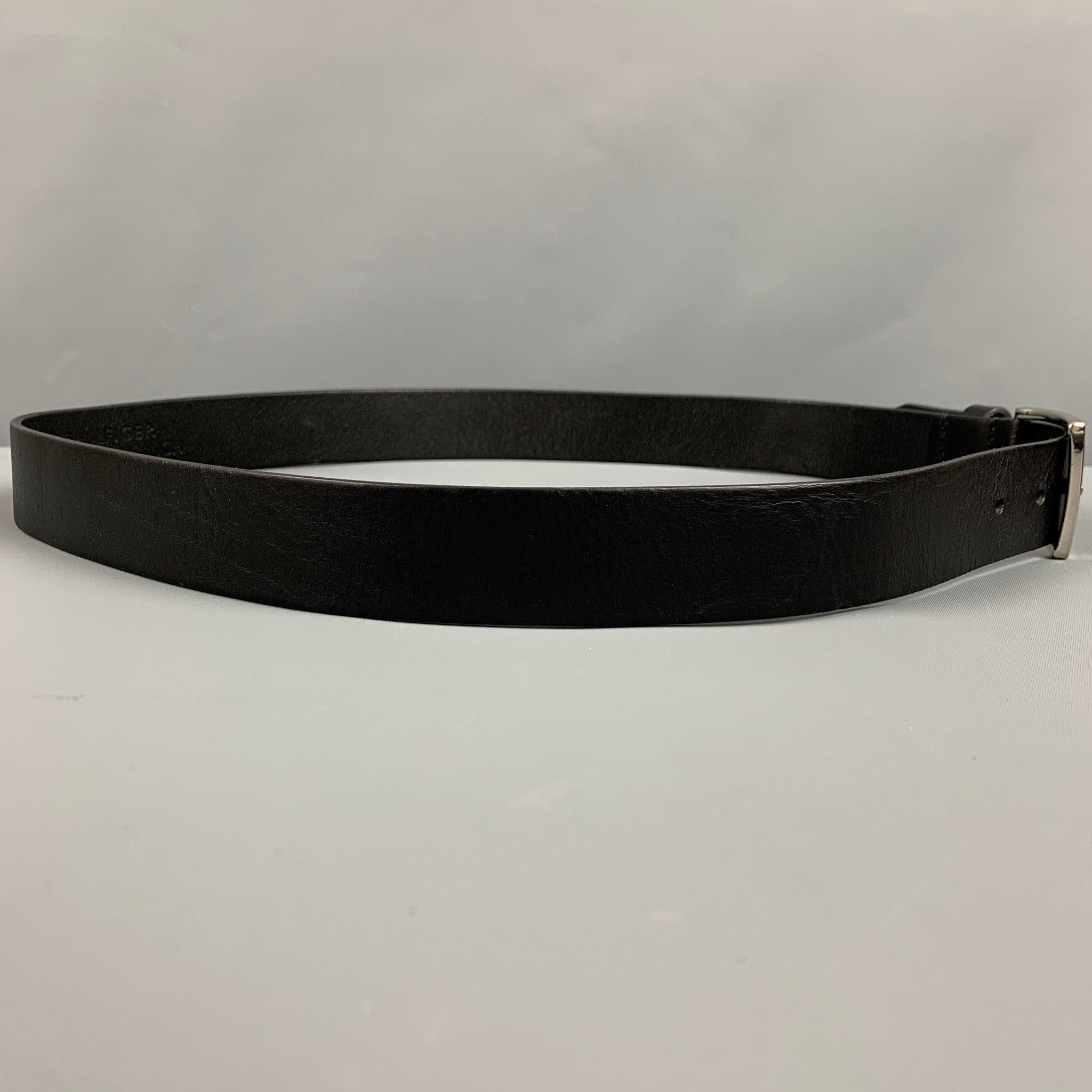 TOMMY HILFIGER belt
in a black leather featuring a silver tone buckle. Made in Romania.Excellent Pre-Owned Condition. 

Marked:   95cm. /38 inches Length: 42.5 inches  Width: 1.5 inches  Fits: 35 inches  - 39 inches  Buckle: 2 inches 
  
  
