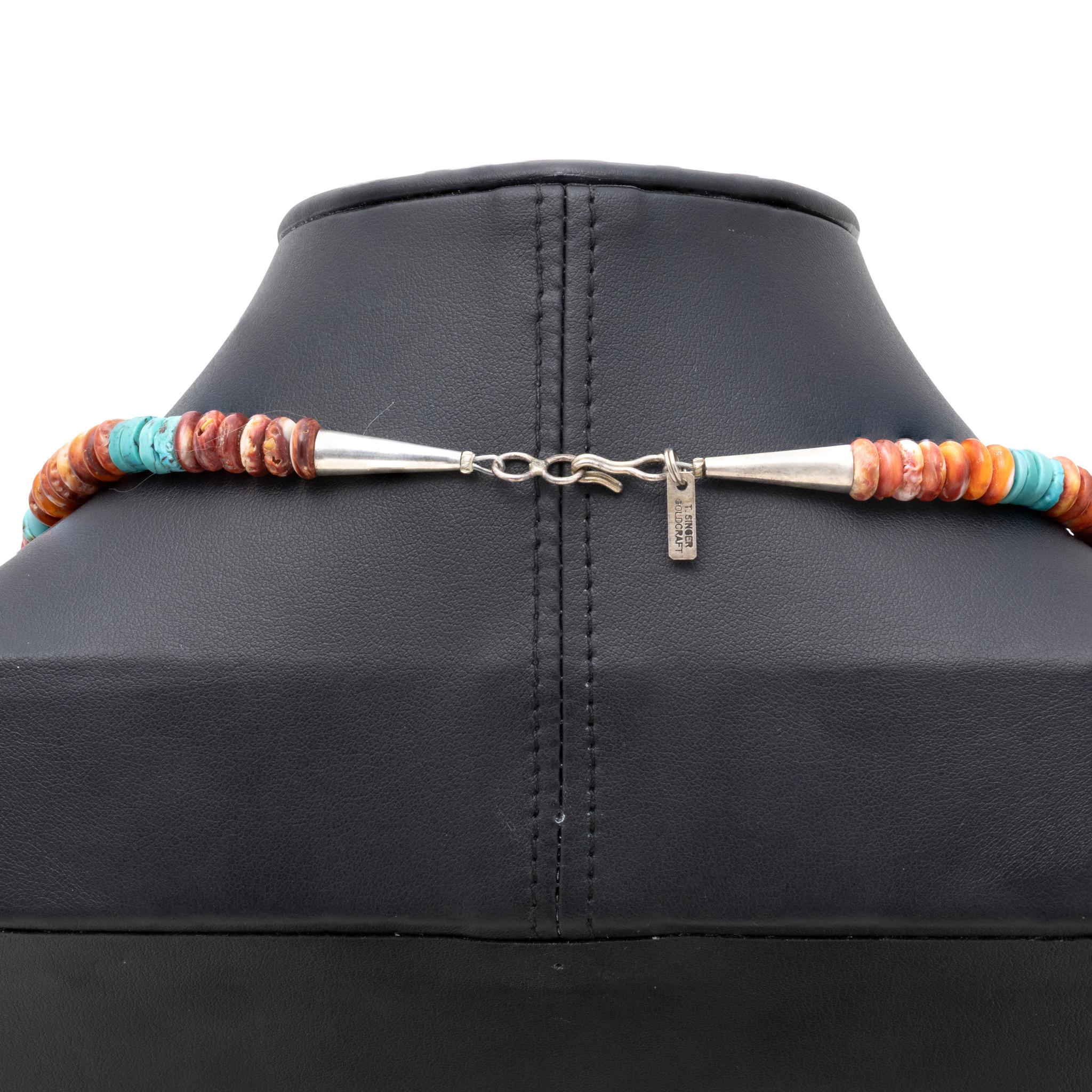 Native American pendant and beaded necklace by Navajo silversmith Tommy Singer (1940-2014). Hollow sterling silver pendant in the form of a bison/buffalo, with overlay design of a Kokopelli, on a necklace comprised of graduated spiny oyster shell