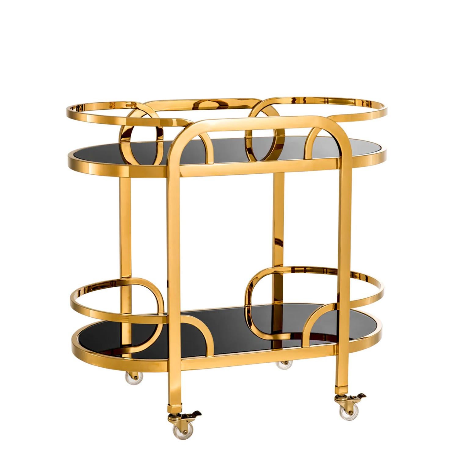 Trolley Tommy ith all structure in polished stainless
steel in gold finish. Up and down tops in smocked 
glass. With 4 clear acrylic rotative castors.