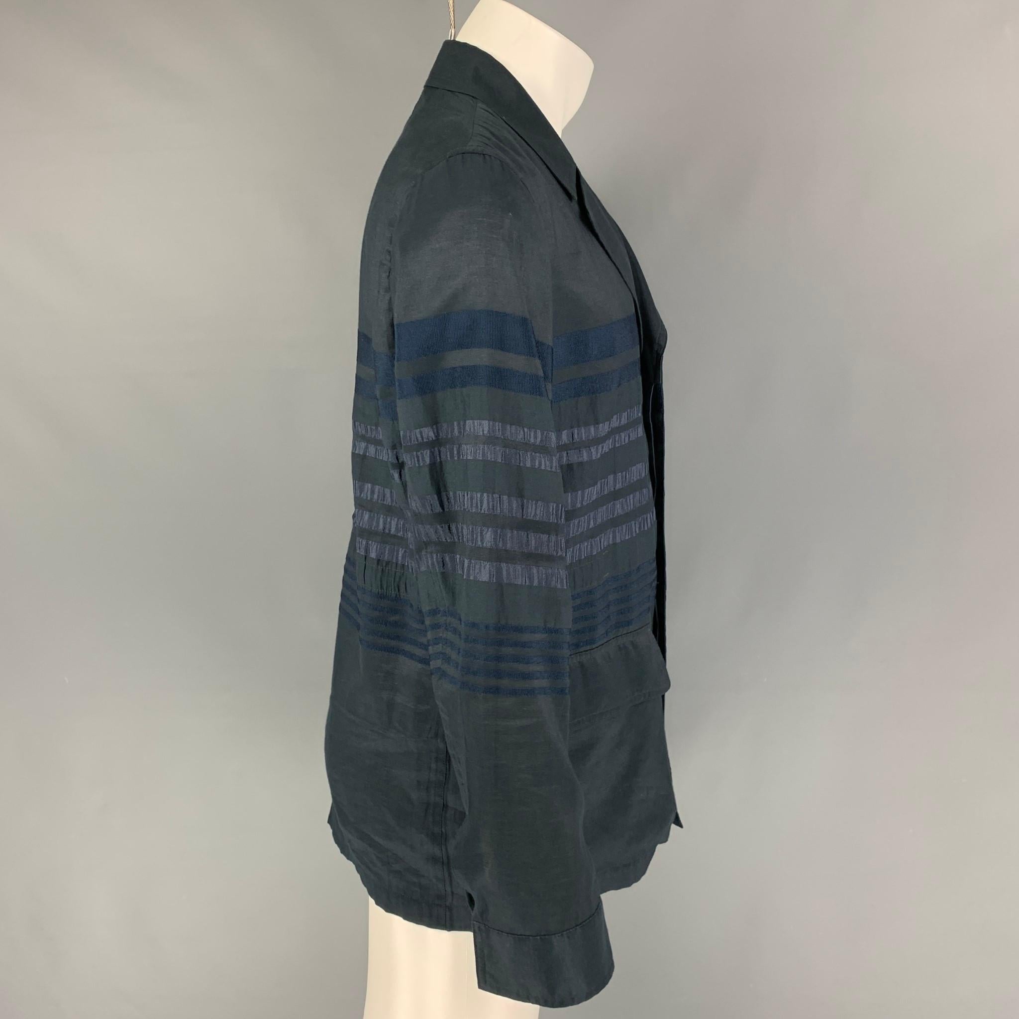 TOMORROWLAND sport coat comes in a dark blue shimmery stripe cotton featuring a notch lapel, flap pockets, and a hidden placket closure. 

Very Good Pre-Owned Condition.
Marked: M

Measurements:

Shoulder: 17.5 in.
Chest: 40 in.
Sleeve: 26 in.   