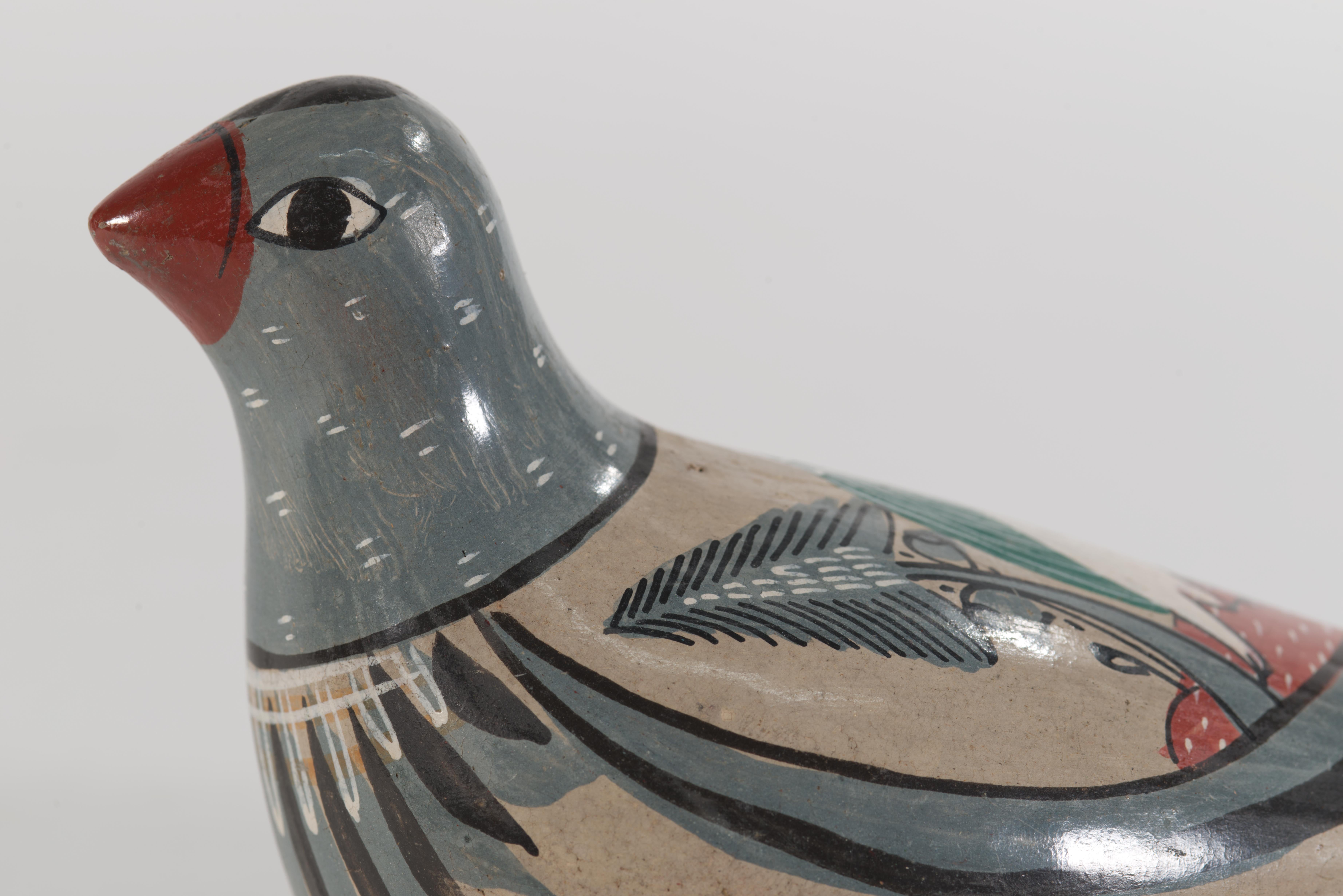 Die bezaubernde Vogelfigur aus Tonala-Töpferware ist mit dem handgemalten Dekor eines weißen Vogels in einer Landschaft verziert, umrahmt von abstrakten Dekorstreifen. Das starke Fold Art-Element des Dekors wird durch die modernistische Form des