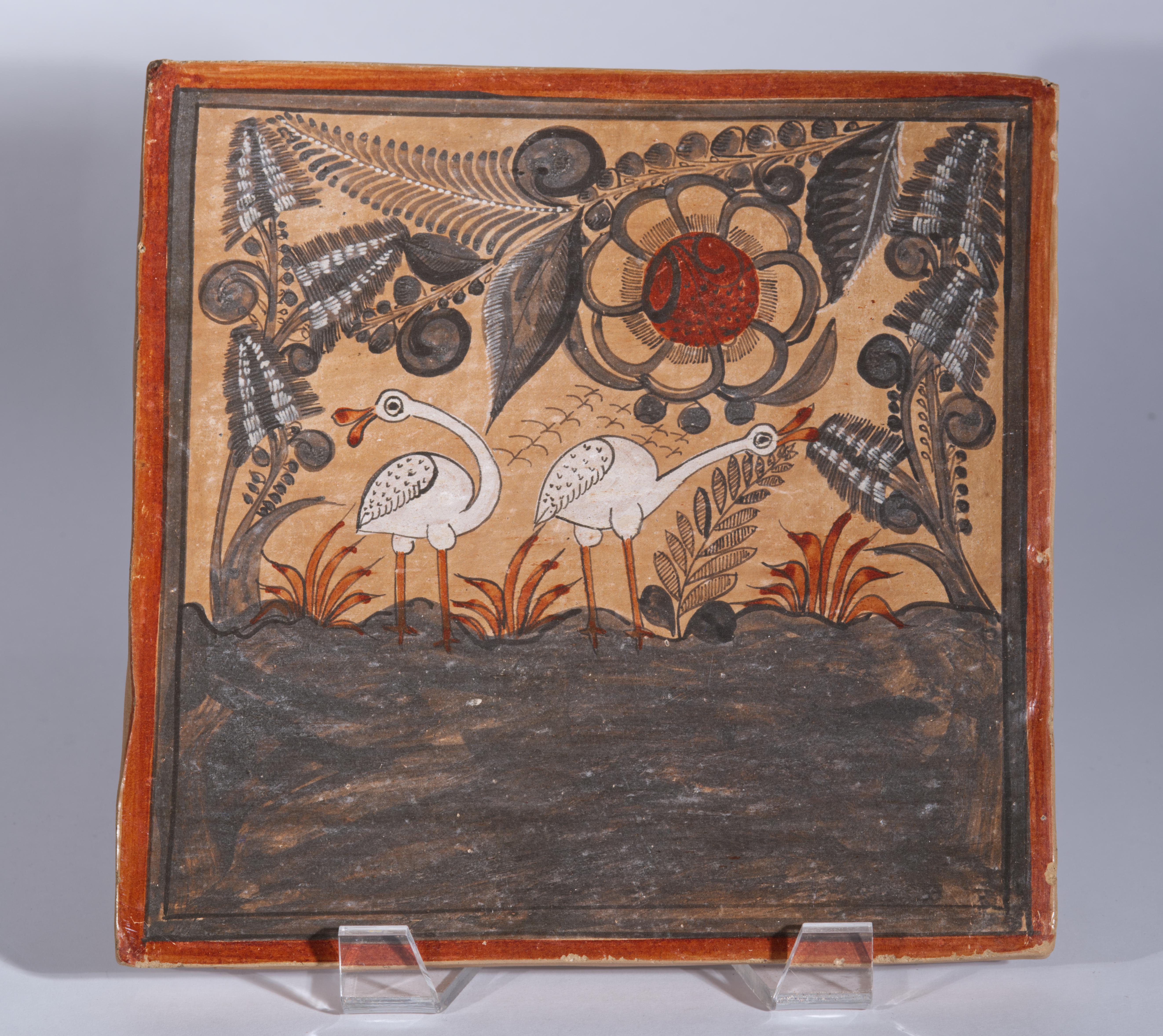 La decoración de pared o azulejo de cerámica cuadrado grande presenta una decoración de estilo Folk Art pintada a mano con un encantador motivo detallado de dos pájaros blancos de pie junto a grandes plantas con flores y hierbas rojas, con una gran