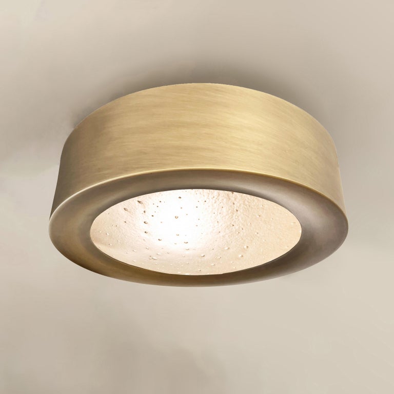 The Tondo flush mount was designed to elavate smaller and low clearance spaces with its 5” drop. The concave bevel holding the convex Murano glass shade and its offset stance make it a highly sculptural piece despite its size. Shown in our Bronzo