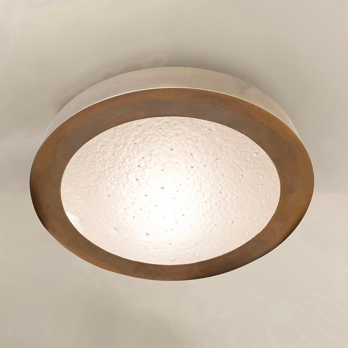The Tondo Grande flush mount was designed to elavate smaller and low clearance spaces with its 4” drop. The concave bevel holding the convex Murano glass shade and its offset stance make it a highly sculptural piece despite its size. Shown in our