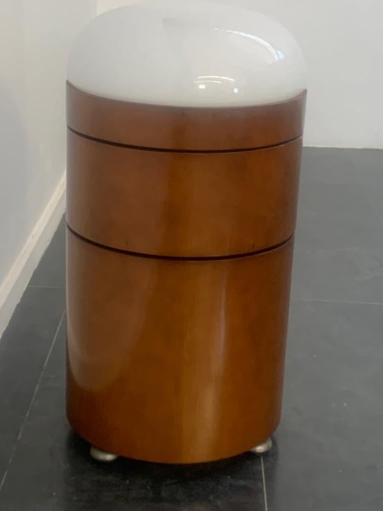 Unique cylindrical bar trolley with dimmable opaline glass dome lamp. The cabinet is of excellent workmanship, made of curved plywood veneered in walnut. The cabinet is divided into two openable compartments. The base is made of wood and cementite