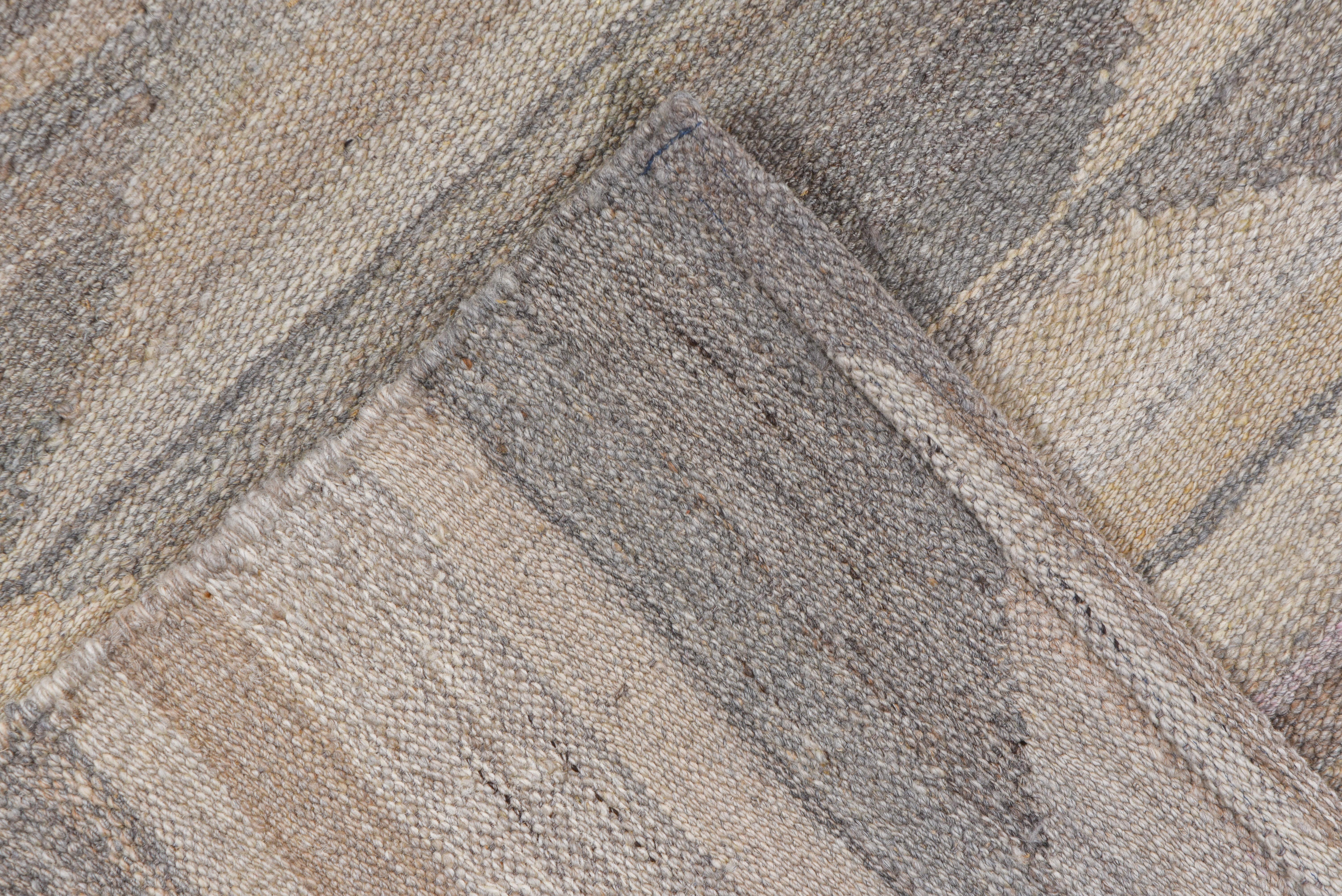 A wave like repeating pattern with contrasting neutrals is woven on this flatweave rug. Tones include, linen, sand, gray and taupe.