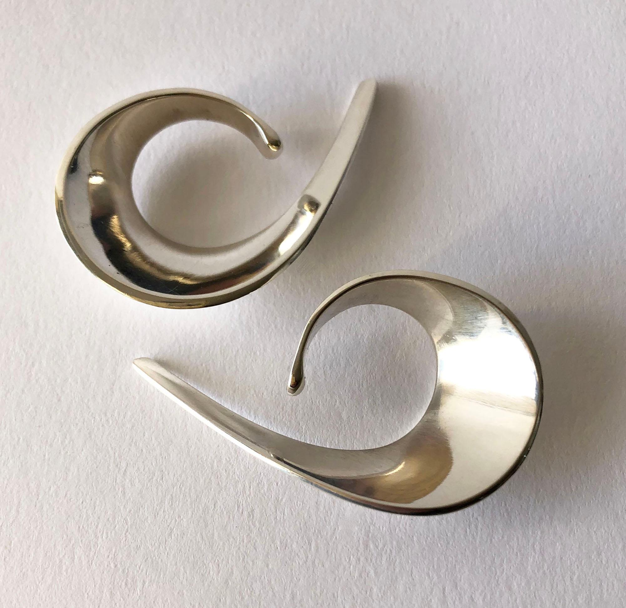 Sterling silver sling earrings created in 1958 by goldsmith/silversmith and jewelry designer, Tone Vigeland. Earrings fit within the ear and have no post or finding.  See my last picture to view how they are worn.  Earrings measure 2