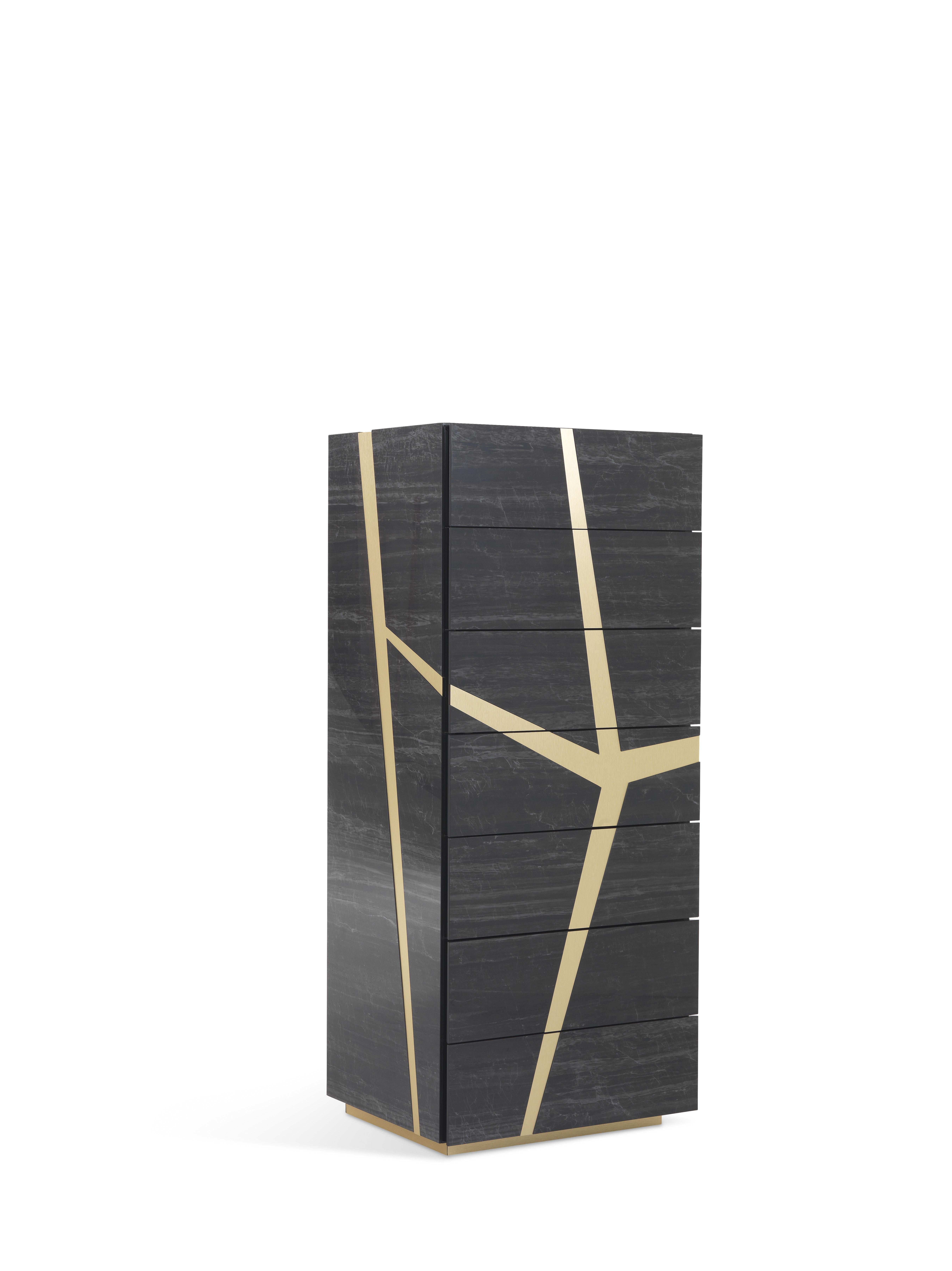 A chest of drawers with contemporary lines and vertical shape that combines functionality and aesthetic value. The piece of furniture is the result of a complex process of the craftsmanship of porcelain stoneware, enriched by metal inserts whose