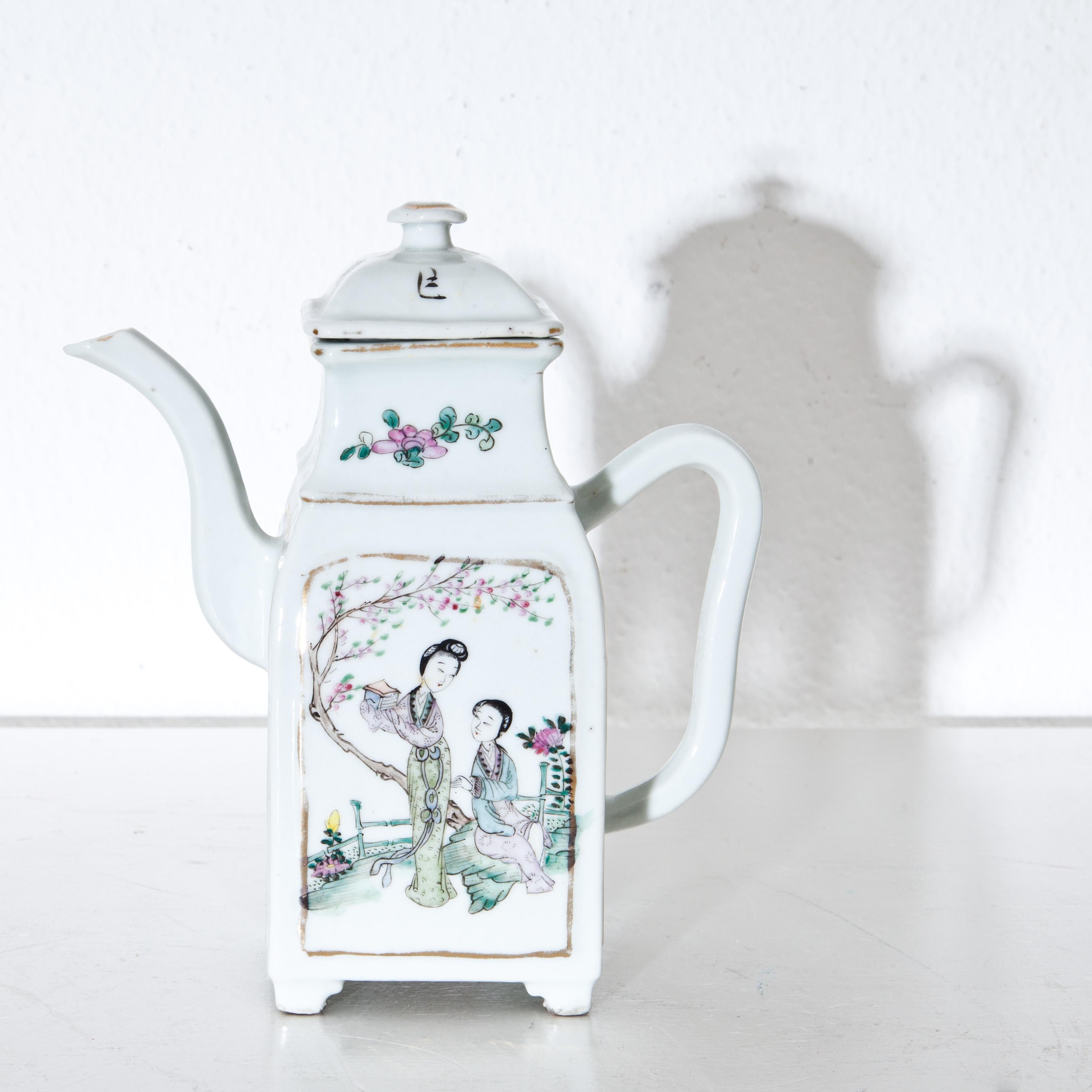 Small porcelain teapot with polychrome figurative scenes on the sides.