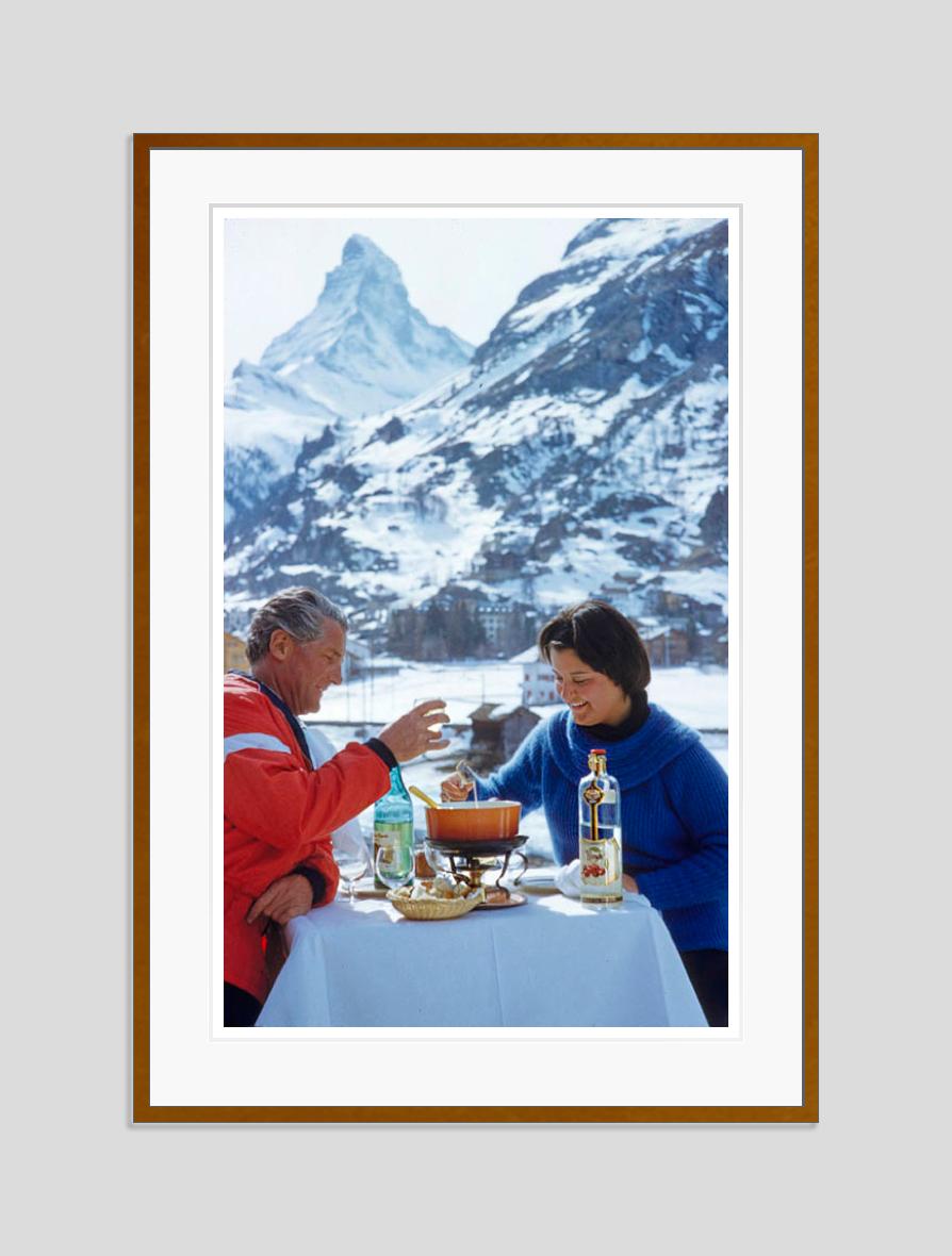 Apres Ski Time 
1959

A couple enjoy an après-ski fondue with the Matterhorn in the background, 1959. 
by Toni Frissell

40 x 30