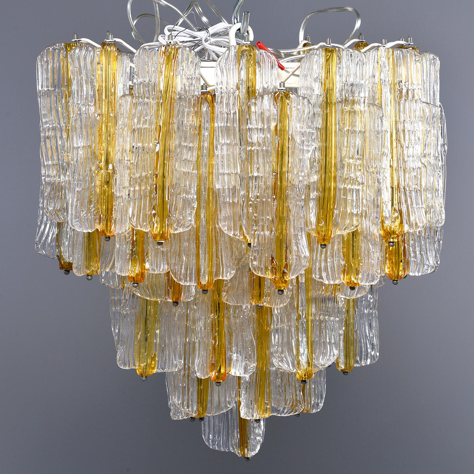 Venini chandelier designed by Toni Zuccheri for Venini features tiers of ribbed clear glass pendants with amber centers. Six regular sized sockets. Chandelier has been rewired for US electrical standards, circa late 1960s-early 1970s.