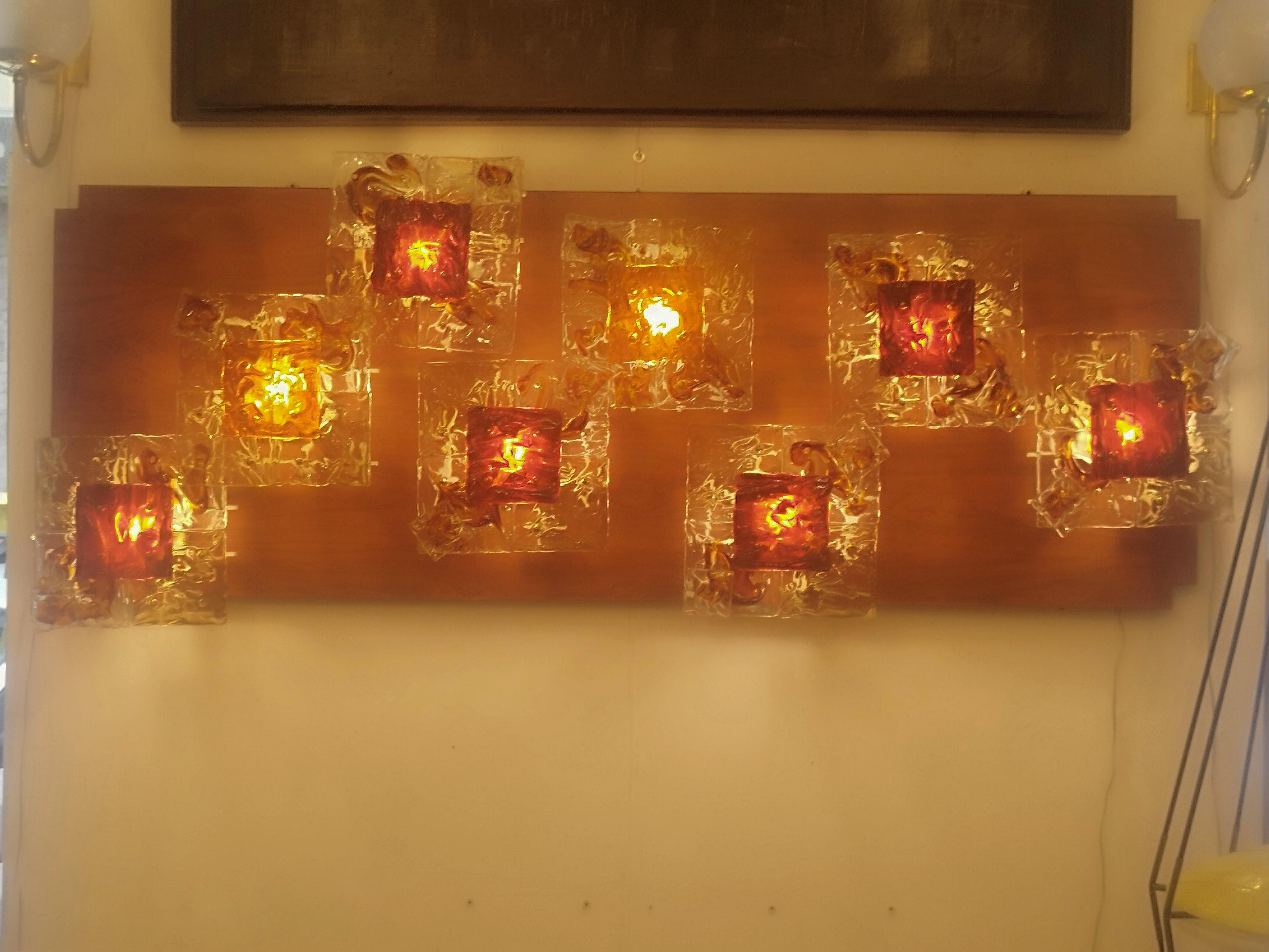 Set of 8 rare and luxurious Mod. Patchwork wall sconces by Tony Zuccheri for Venini Murano. 
Clear, amber, yellow and orange heat-worked glass are mounted on a white lacquered metal frame with brass details then fixed on a wooden panel, 1970s.