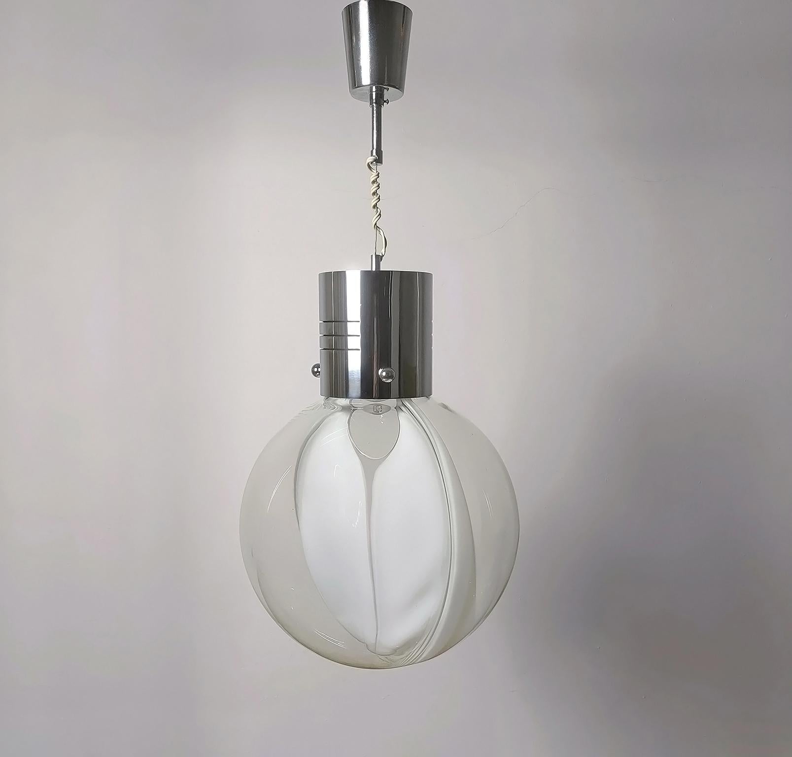 Ceiling or Hanging lamp from the 'Membrane' series, designed by Toni Zuccheri and created between 1966 and 1968 by the famous Italian company Venini.

The lamp presents a round shape globe in blown clear glass, which has inside a milky glass