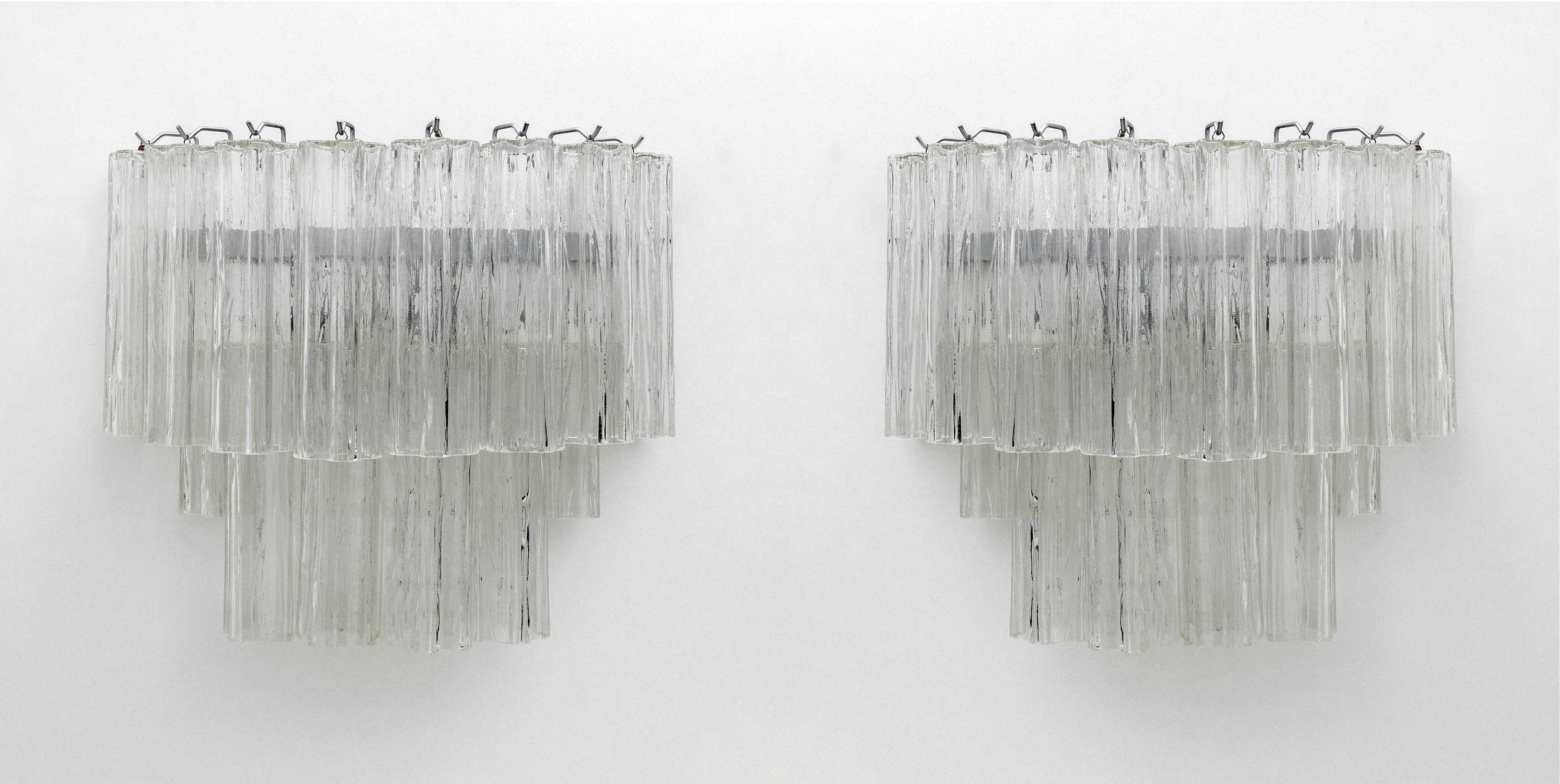 Toni Zuccheri for Venini 1970s, pair of wall lamps each composed of 14 Murano glass trunks.
Rewired again, each lamp has two E14 lamp holders, which can also be used in the USA with E12 socket bulbs.
The structure is in chrome painted metal