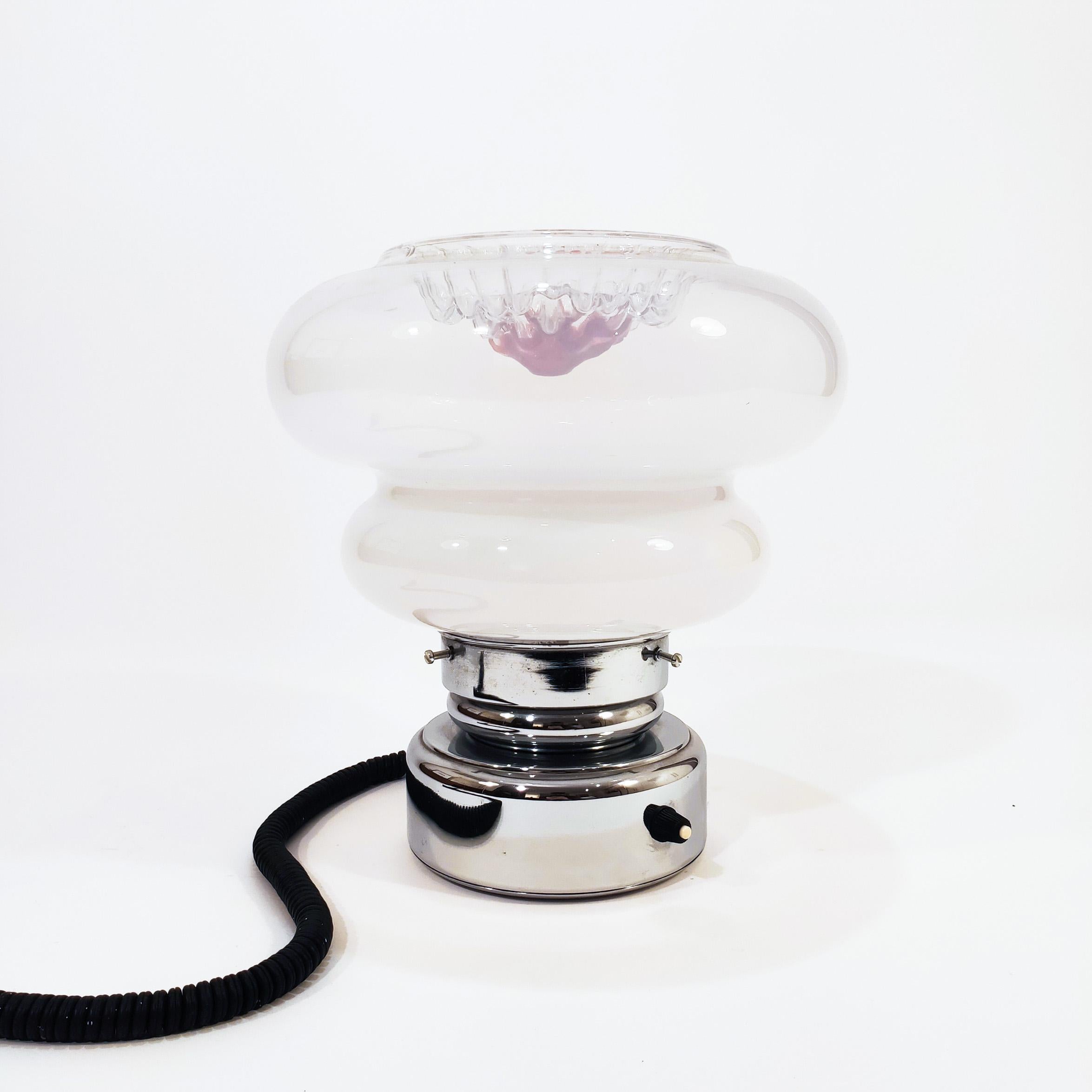 Italian Spaceage table lamp in the style of Toni Zuccheri's artistic creations. Murano glass tulip with organic shapes combining the smoky tone with transparent and red. Chrome metal base structure with built-in switch. All original. Very much in