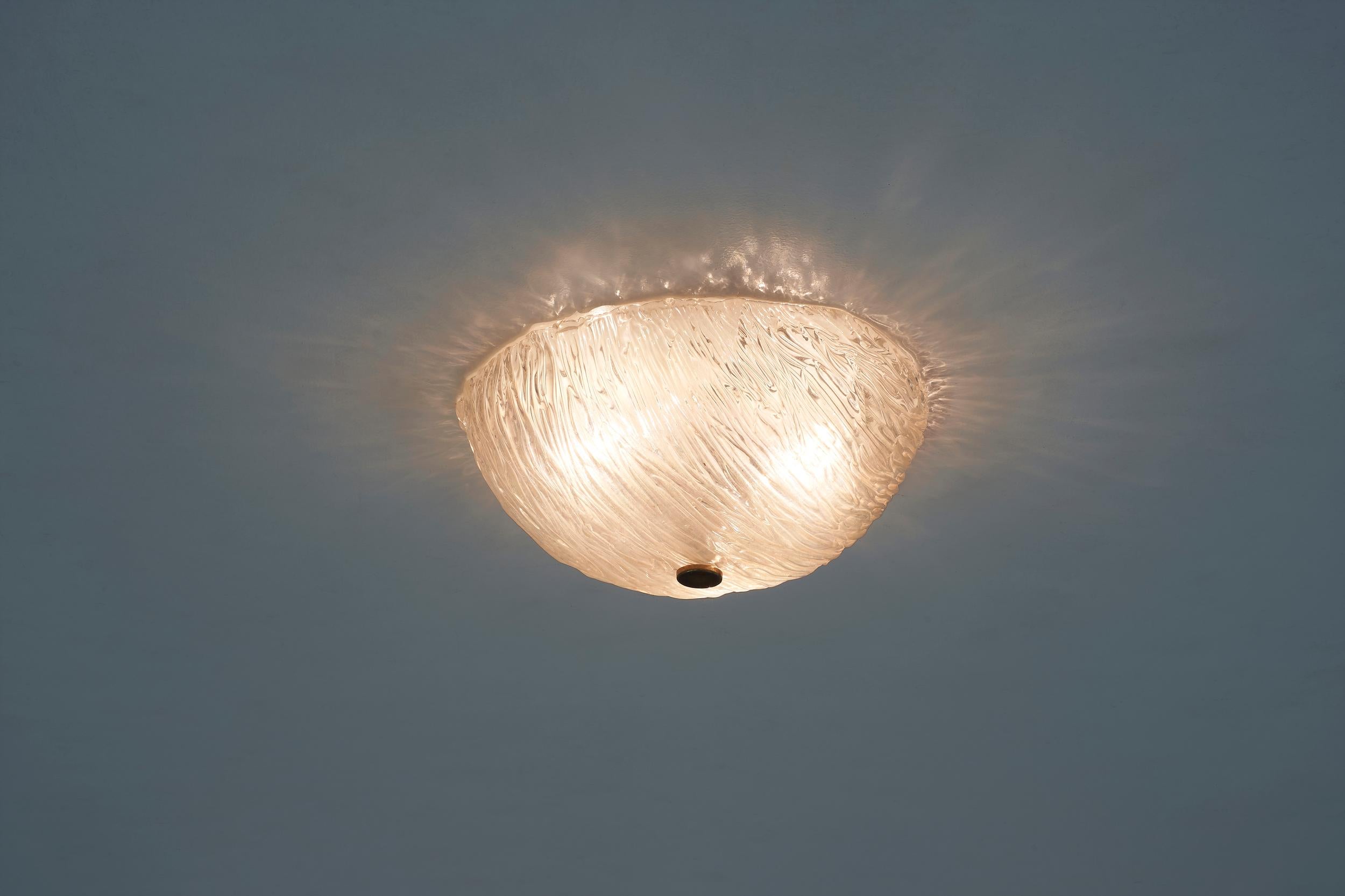Simple and elegant ceiling light created by Toni Zuccheri for the world leading artistic glass company Venini, based in Murano. This plafoniere has a structure in metal and brass while the glass is made out of the typical Corteccia Murano: with its