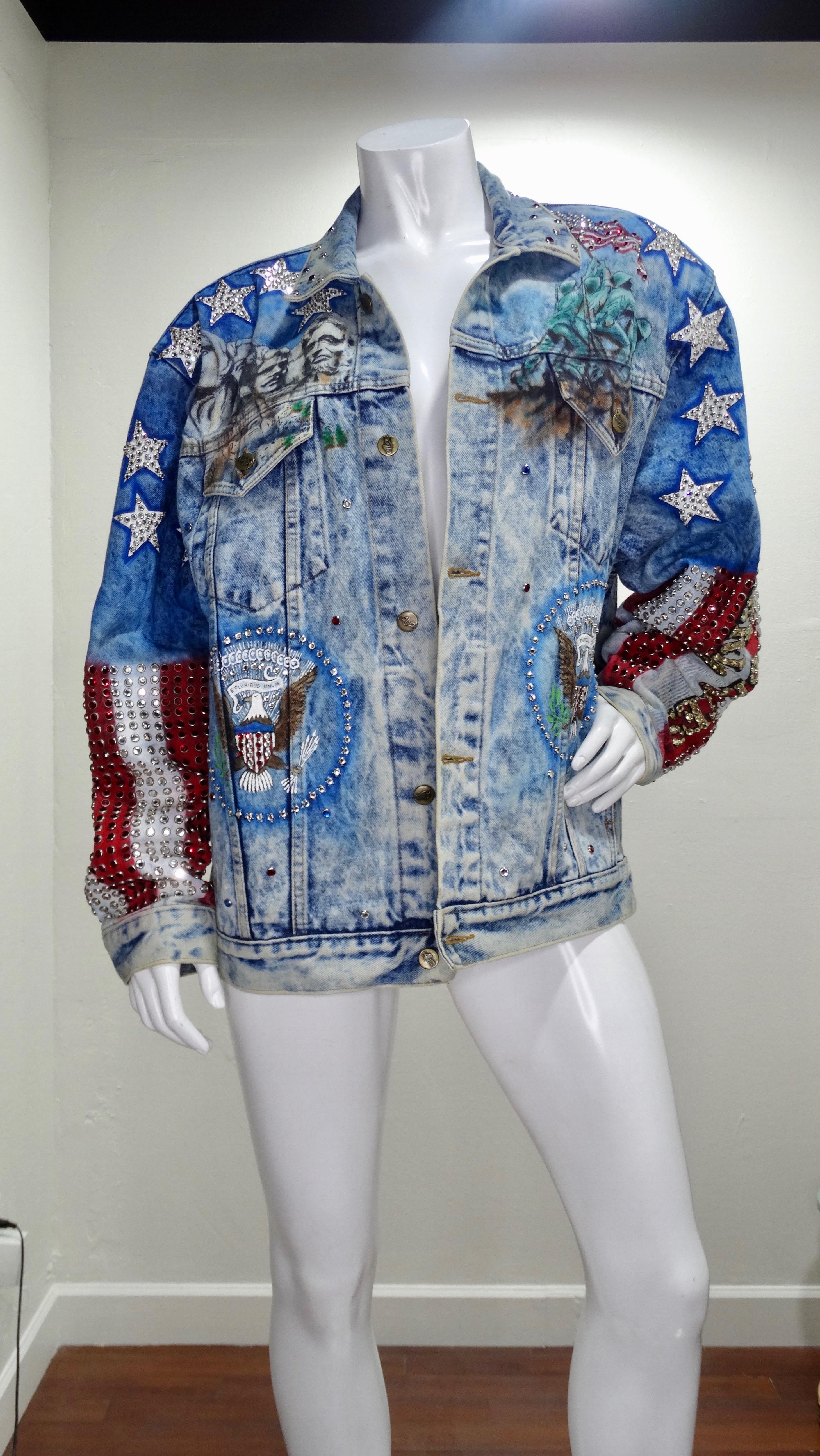 Show off your stars and stripes with this Tony Alamo jean jacket! Circa 1987, this oversized jean jacket features an acid wash, red/white/blue airbrushing, brass toned buttons, two front pockets and eye-catching rhinestone embellishing throughout.