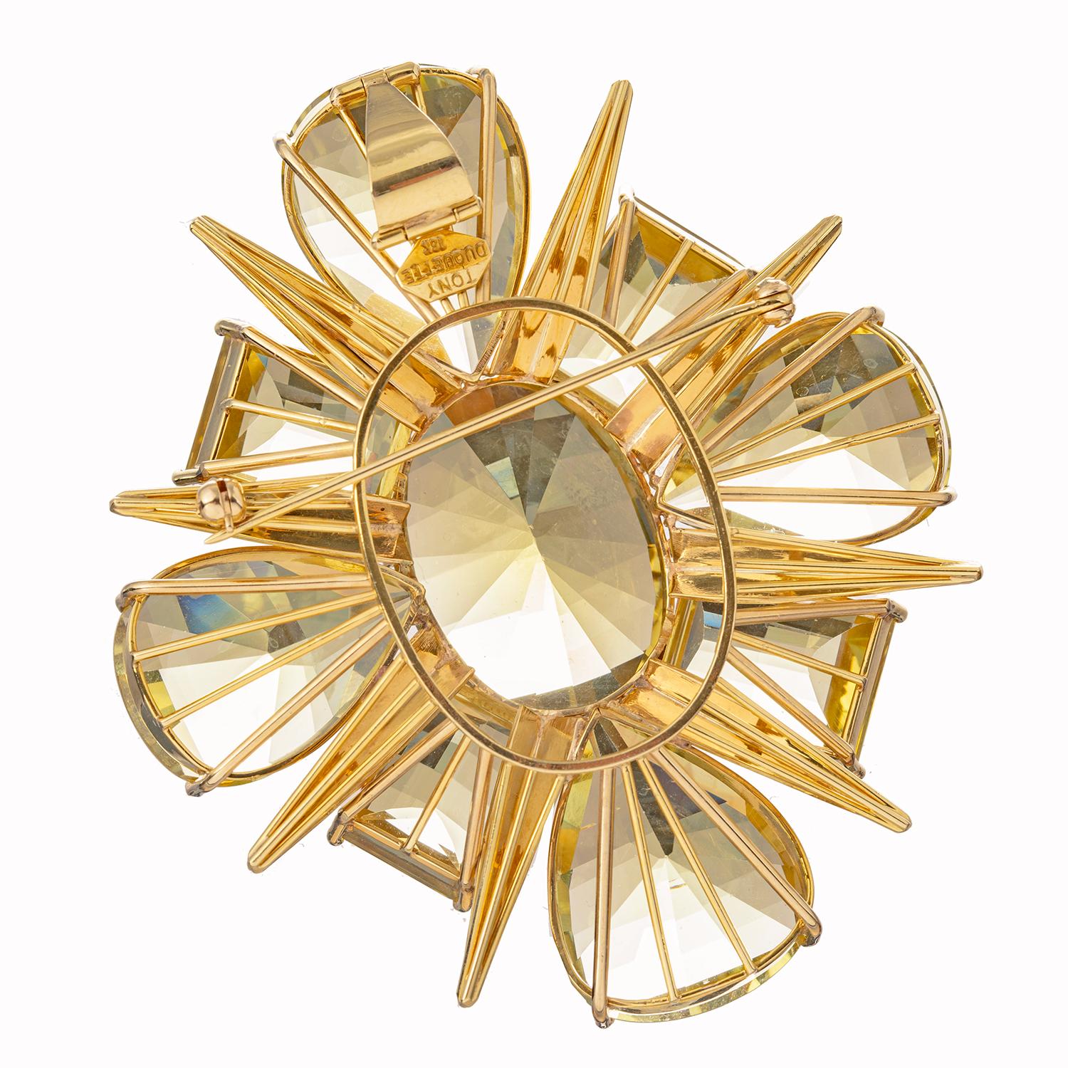 Citrine starburst pendant brooch, featuring pear, oval and square-shaped citrine set in 18k yellow gold.  Hinged fold down pendant loop at top, as well as pin stem, on underside.  Signed 'TONY DUQUETTE 18K'.  Dimensions: 3.1