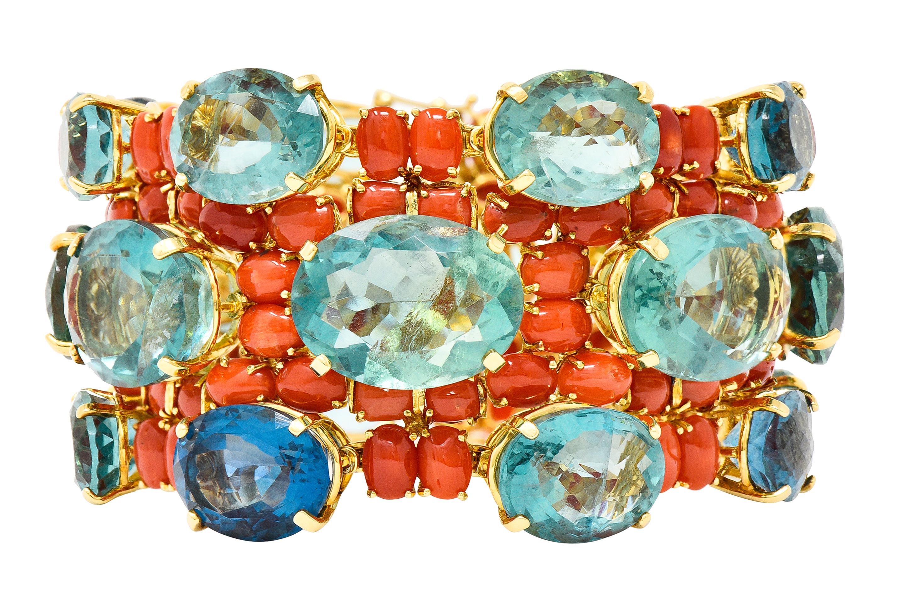 Bracelet is comprised of oval cut fluorite and coral cabochons prong set in meshed gold baskets. Fluorite is transparent bluish-green in color with medium to light saturation and natural inclusions. Ranging in size from 1.0 x 12.0 mm to 15.0 x 20.0