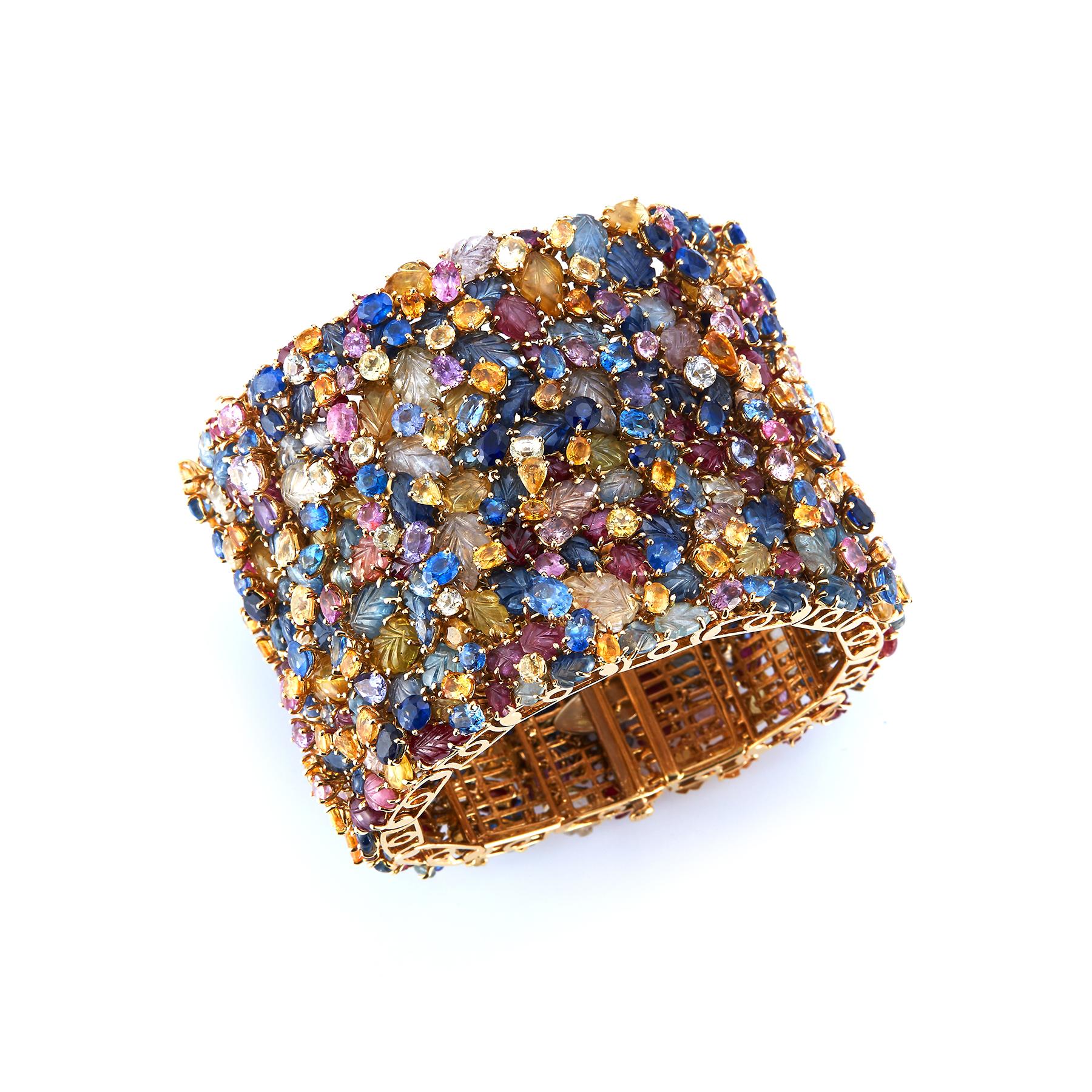 Tony Duquette Mehrfarben-Saphir-Armband 
Dieses Armband besteht aus verschieden geformten, facettierten und geschnitzten farbigen Saphiren, darunter blaue, gelbe, rosa und geschnitzte Rubine.
18k Gelbgold.
Unterzeichnet von Tony