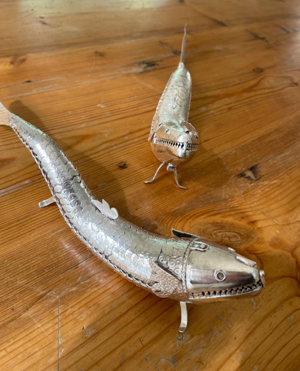 Coppia di pesci identici in argento Sterling modellati in modo realistico con sezioni articolate che permettono al corpo di muoversi da un lato all'altro. Scopo originale: scatola di spezie per pesci. Prodotto in Germania. Provenienza: Dalla