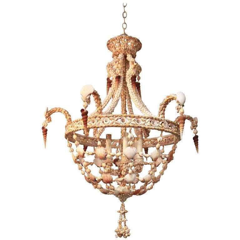 This stylish and chic seashell encrusted chandelier is very much in the style of pieces created by Tony Duquette and the era of Hollywood Regency. The piece is quite subtle and yet dramatic with its form and coloration.

Note: Piece requires six