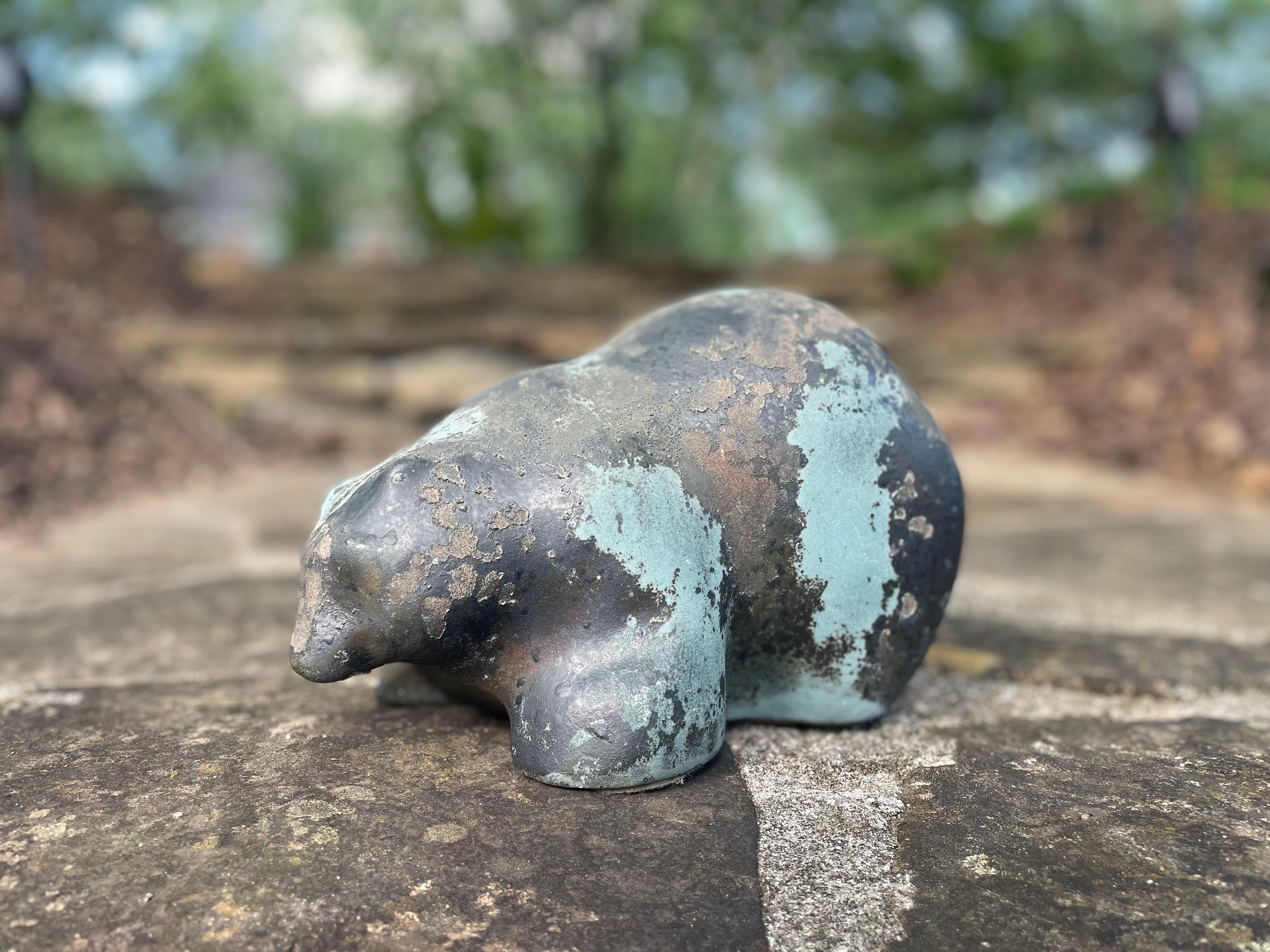 Questo sorprendente orso in ceramica cotta a fuoco raku dell'artista Tomi Evans è una potente miscela di eleganza terrena e forma naturale grezza. Scolpito con linee delicate e astratte, l'orso incarna una forza tranquilla, con una postura che evoca