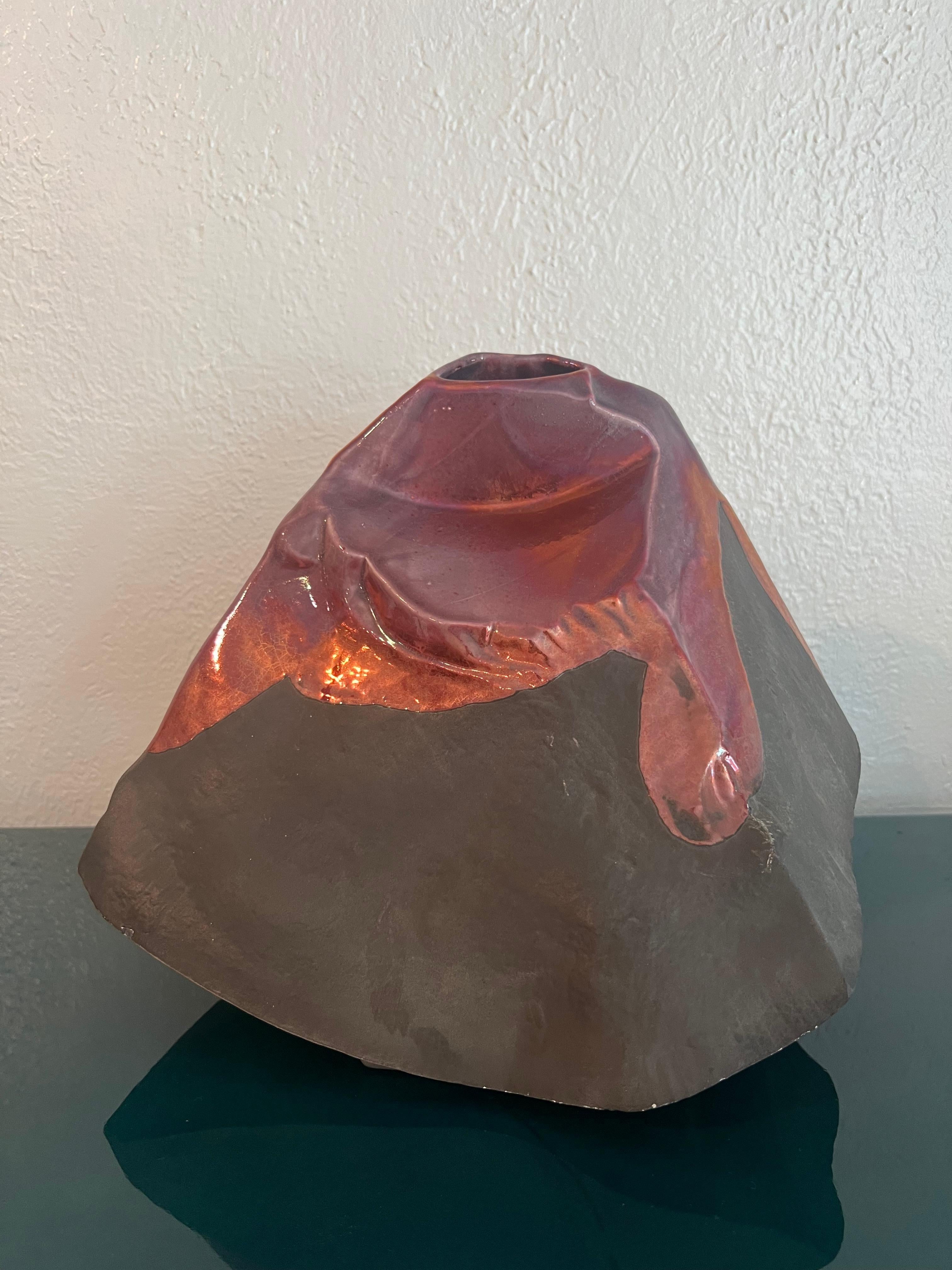 Tony Evans glazed raku vase. Rare form, possibly made to resemble a volcano. Minor areas of wear to finish (please refer to photos). Additional photos available upon request. 

Would work well in a variety of interiors such as modern, mid century