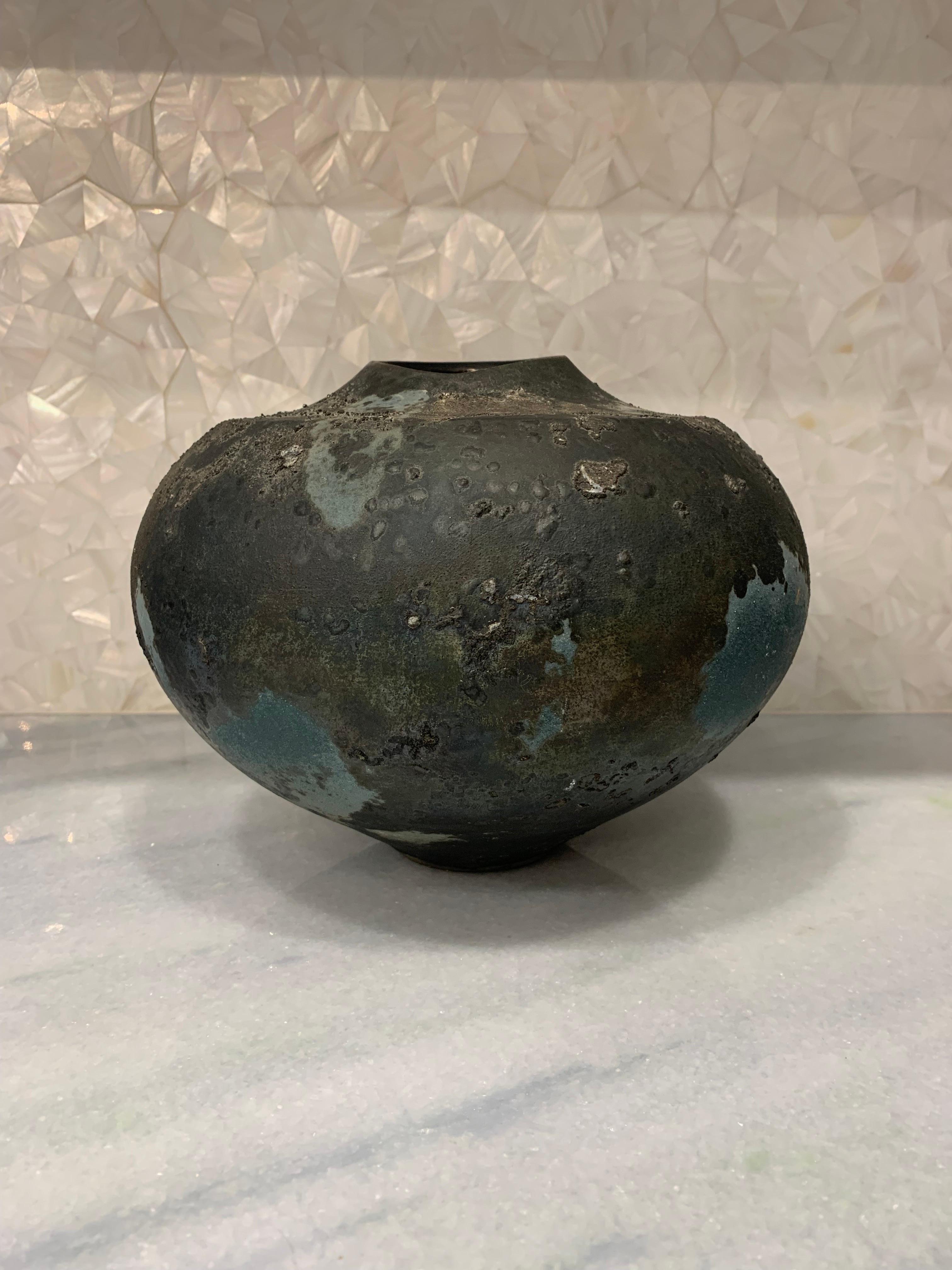 Large and beautiful multi colored glazed raku vase. Done in the traditional raku style of Tony Evans. Beautiful textured surface. Resembles a giant blueberry. Signed underneath Evans - 31. 

Measures; 9.5