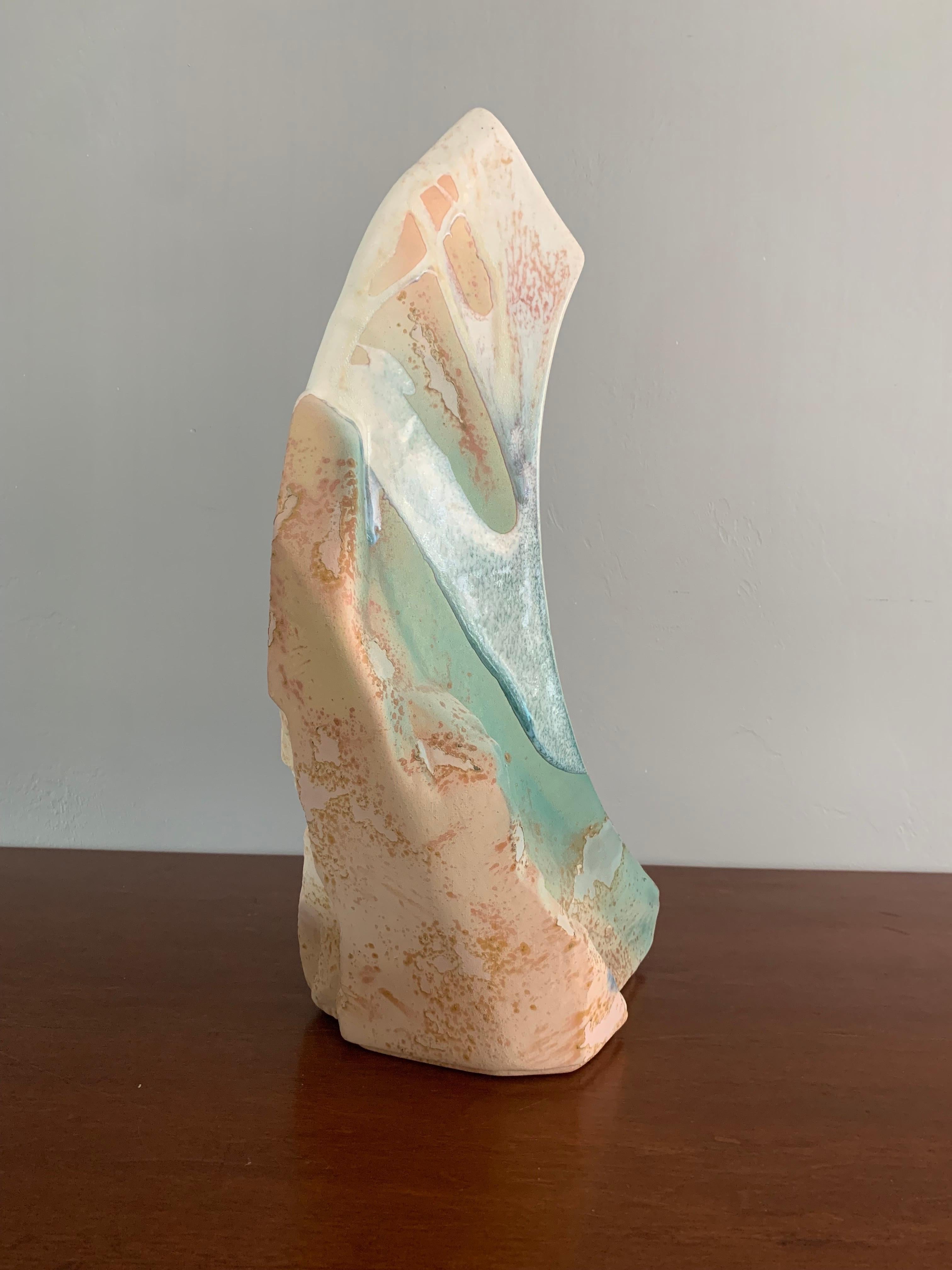 Grand et magnifique vase en raku multicolore. Réalisé dans le style traditionnel raku par le célèbre artiste américain Tony Evans. La texture du raku met en valeur les courbes et la forme du vase, qui ressemble à une crête de montagne. Signé en