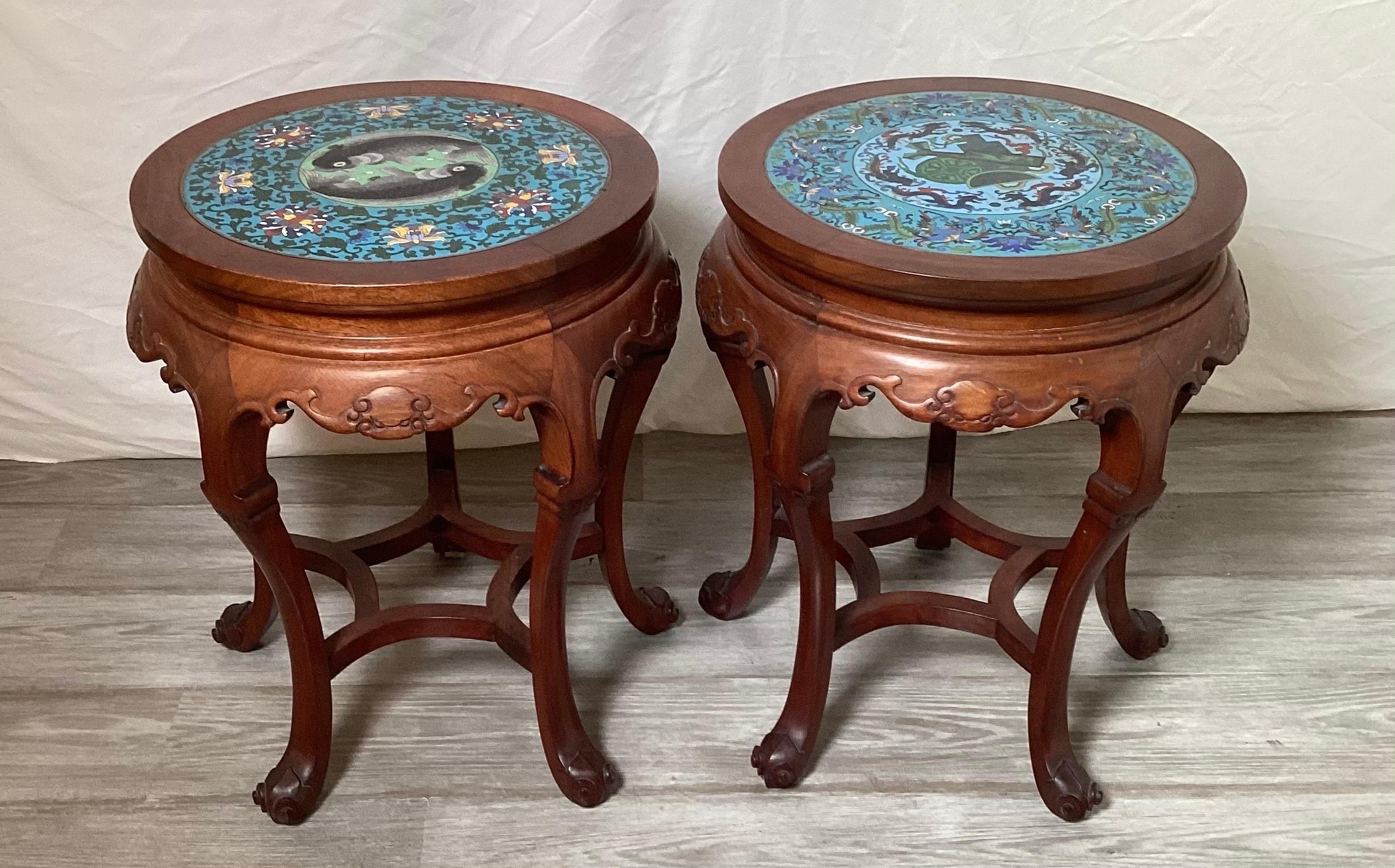 Ein elegantes Paar handgeschnitzter Tische/Ständer aus Hung-Mu-Holz mit Cloisonné-Platten.  Die Aufsätze sind mit Karpfen, Symbolen, Drachen und Phönixvögeln gestaltet,  Die handgeschnitzten Sockel mit Fledermausmotiven und geschwungenen Beinen