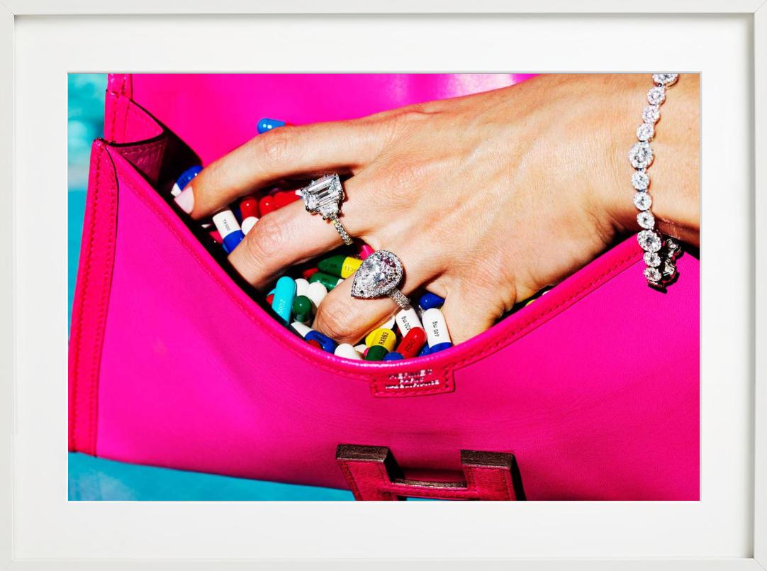 Píldoras de Beverly Hills, coger píldoras de una bolsa rosa, Fotografía artística - Figurative Photograph Rosa de Tony Kelly