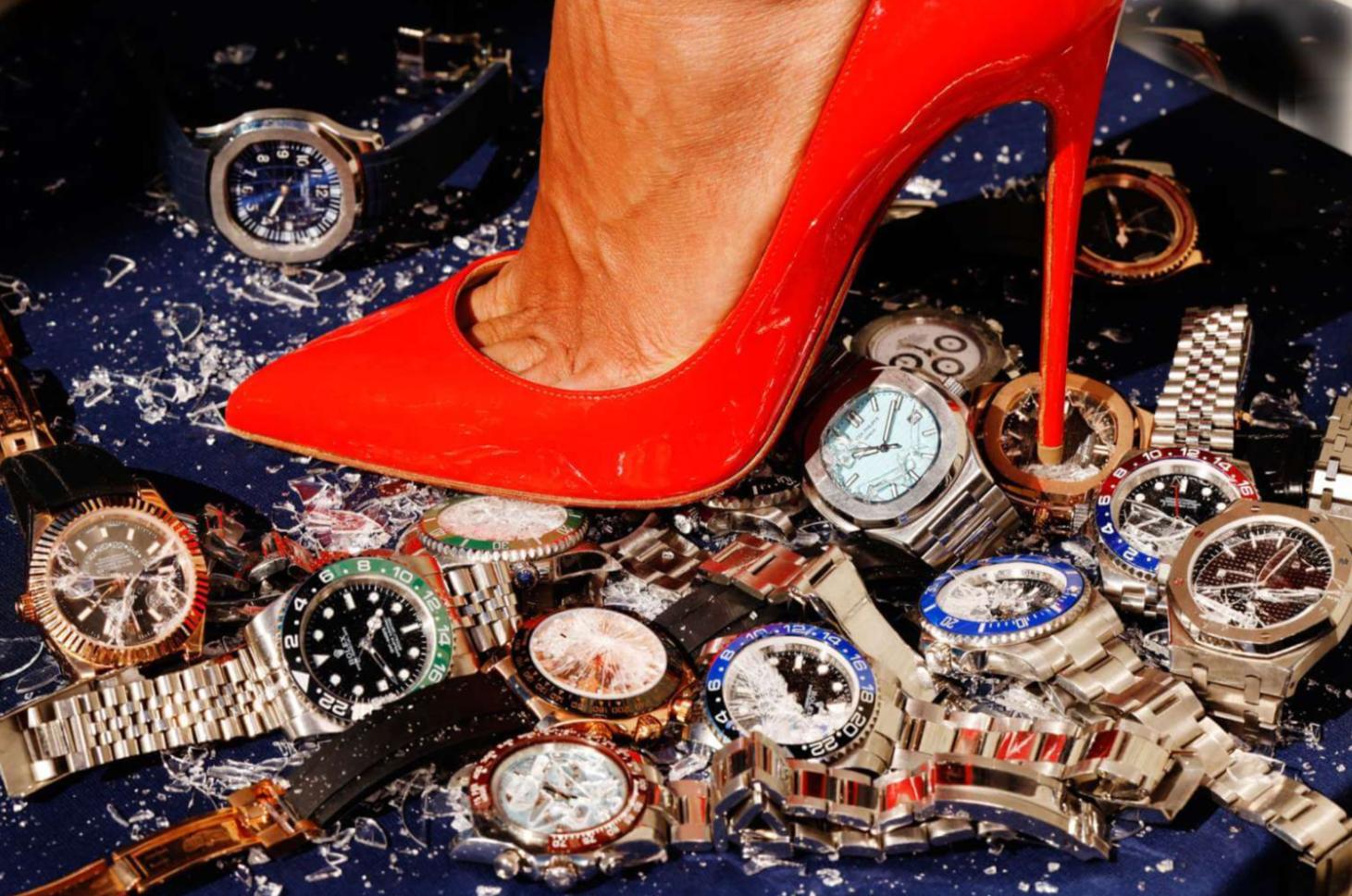 Color Photograph di Tony Kelly - Up & Up - primo piano di un tacco rosso che schiaccia alcuni Rolex, Fine Art Photography