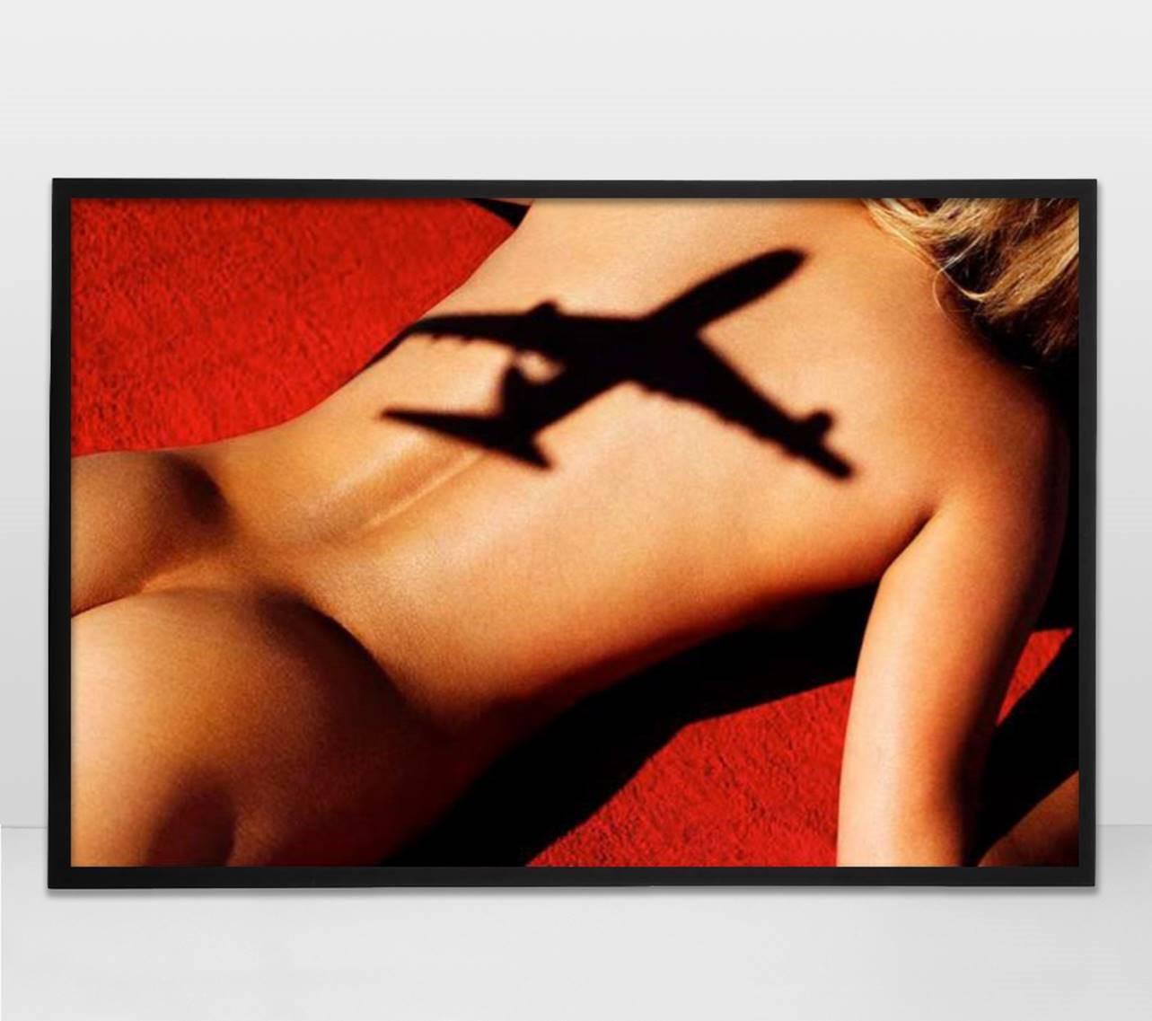 Flight 5 - nude portrait of a woman sunbathing overshadowed by an airplane - Photograph by Tony Kelly