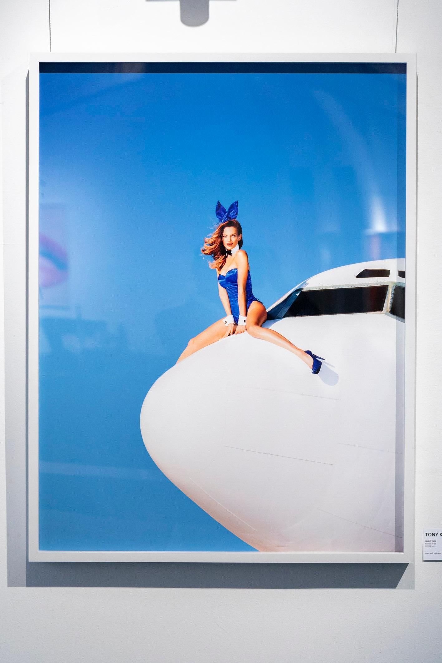 Flight TK75 - Modell in buntem Kostüm sitzend auf Plane, Kunstfotografie 2014 im Angebot 1