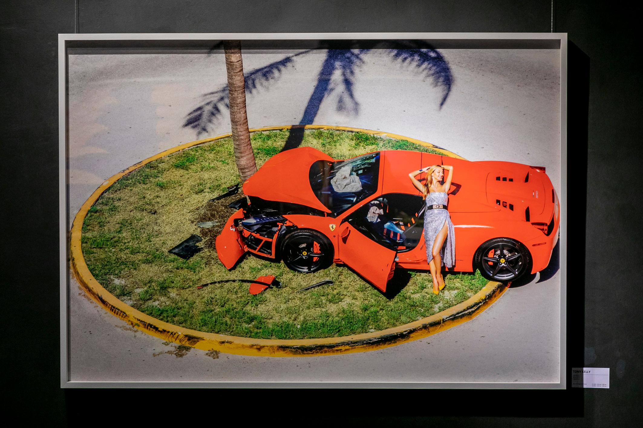 Miami Car Crash - Red Ferrari crashed on a Palmtree, fine art photography, 2019 - Photograph by Tony Kelly