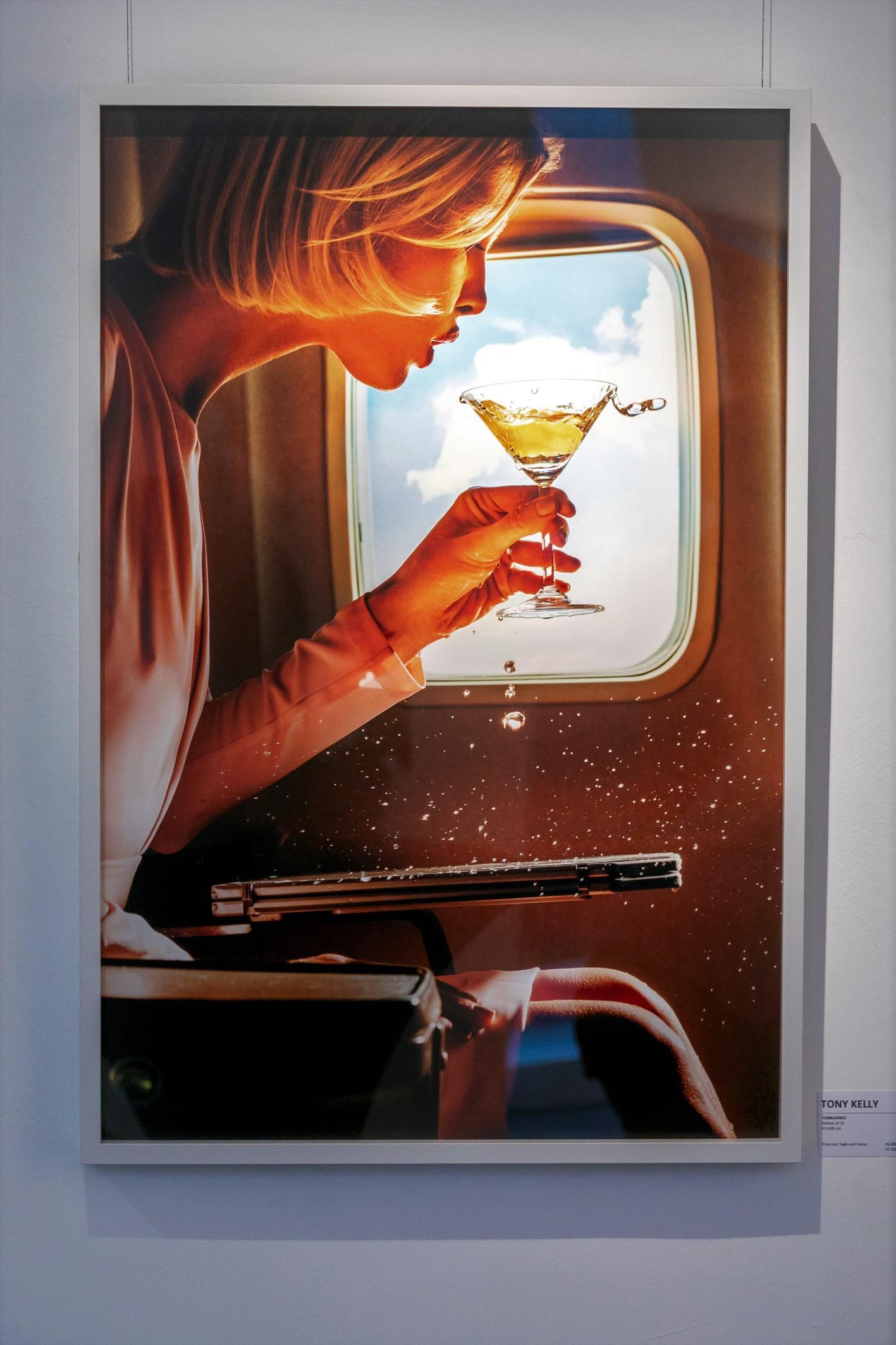 Turbulence - woman spilling champagne in an airplane, fine art photography, 2019 - Photograph by Tony Kelly